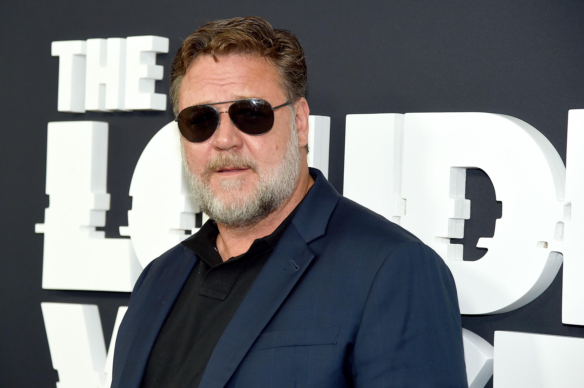 Russell Crowe à la première de « The Loudest Voice » le 24 juin 2019 à New York, vêtu d'un blazer bleu marine sur un polo noir et de lunettes de soleil aviateur. Avec sa barbe grise et sa silhouette plus trapue, l'acteur affichait un look imposant pendant une période de transformation physique pour son rôle de Roger Ailes dans la série Showtime.