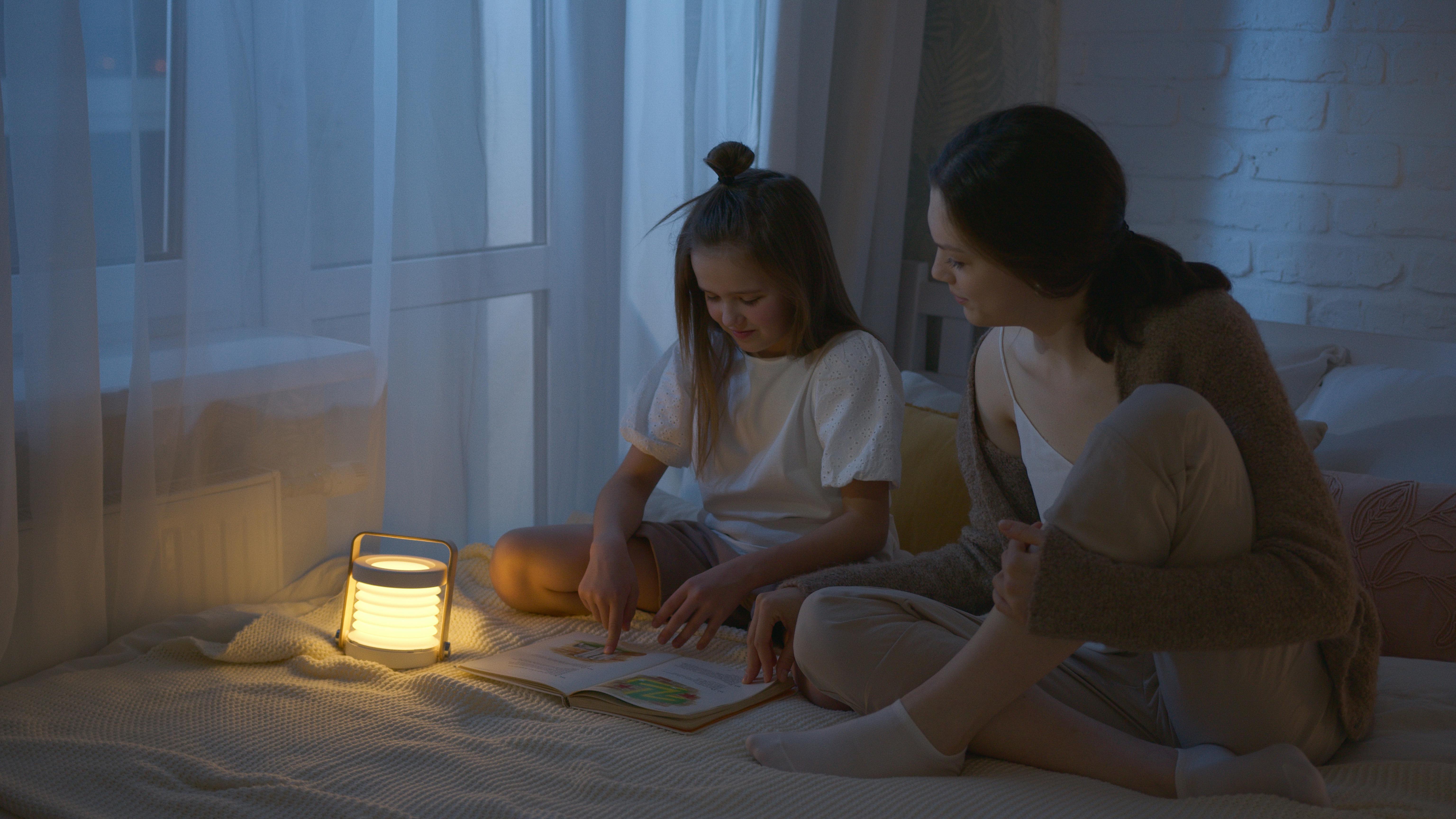 Une femme et une fille assises sur un lit avec un livre | Source : Pexels