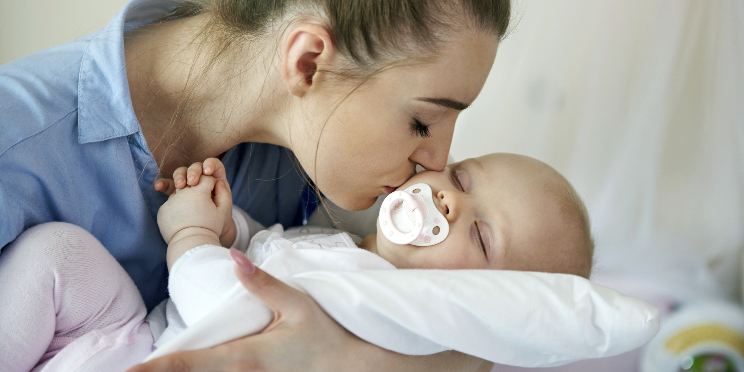 Une femme embrasse son bébé | Source : Freepik