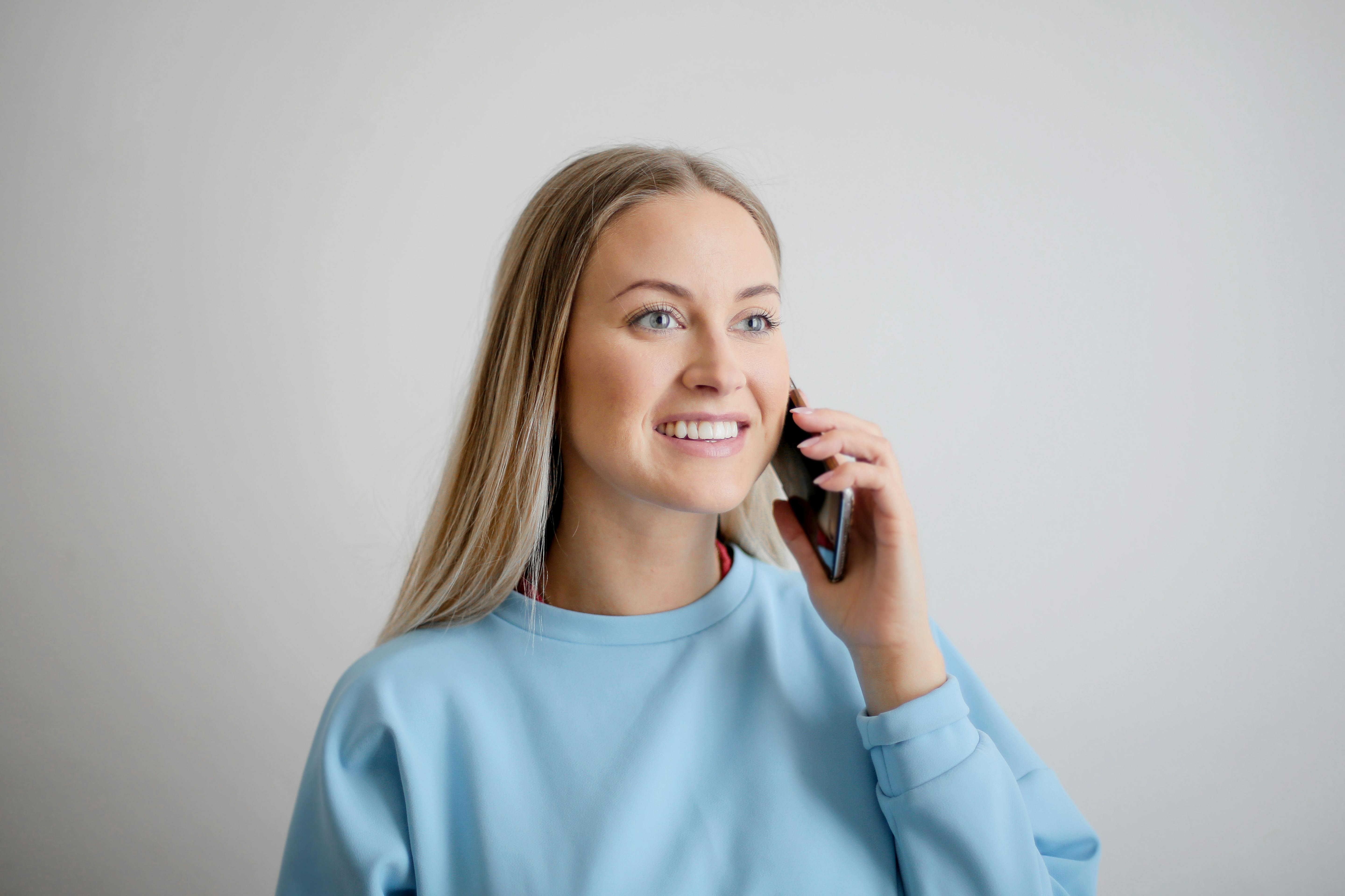 Une femme souriante qui parle au téléphone | Source : Pexels