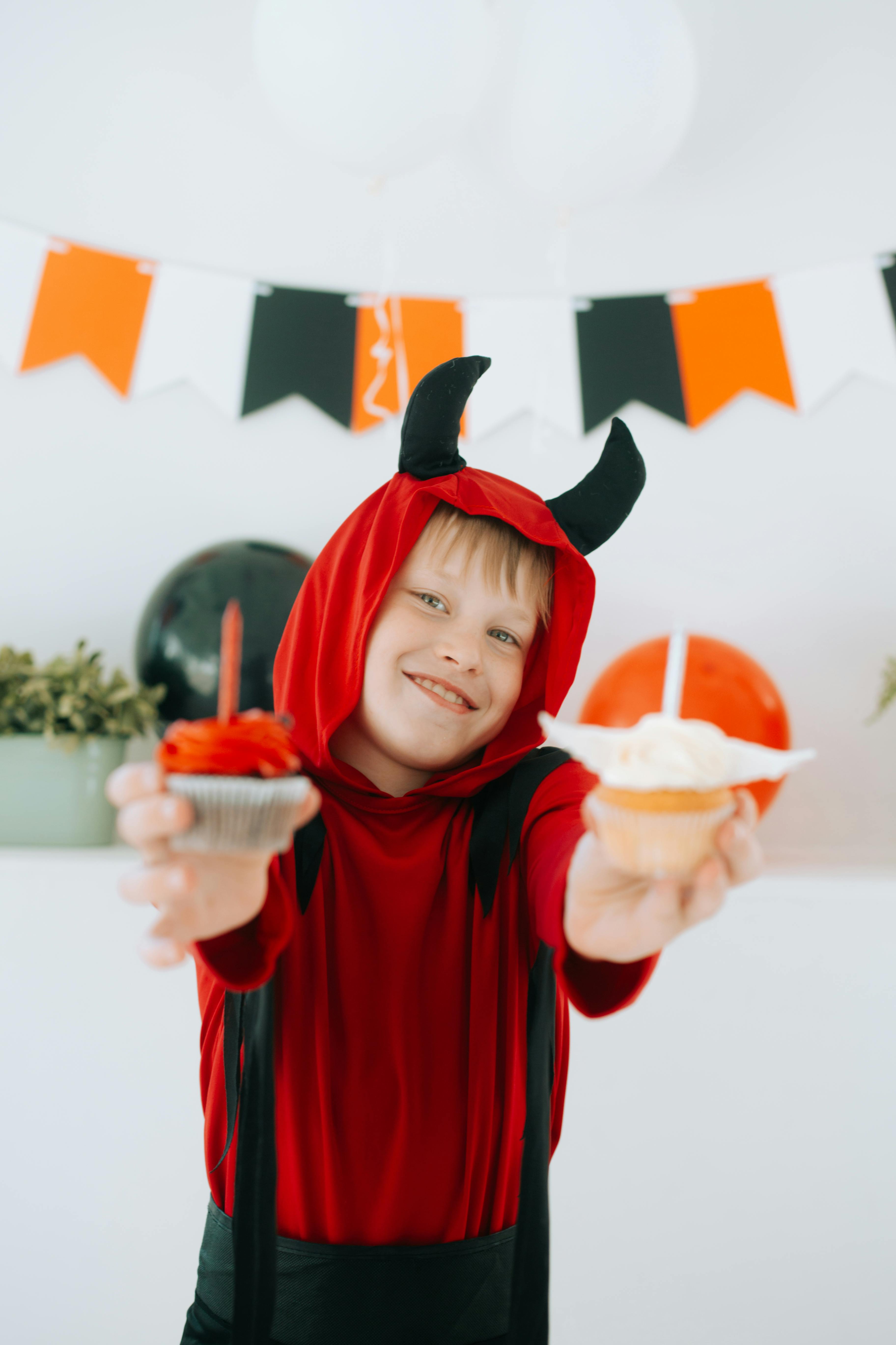 Un petit garçon habillé pour Halloween et tenant des friandises | Source : Pexels