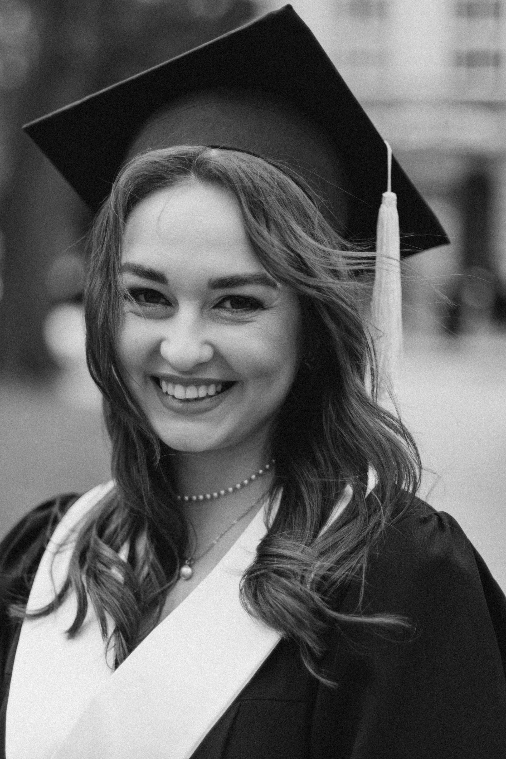 Photo en niveaux de gris d'une jeune femme lors de sa remise de diplôme | Source : Pexels