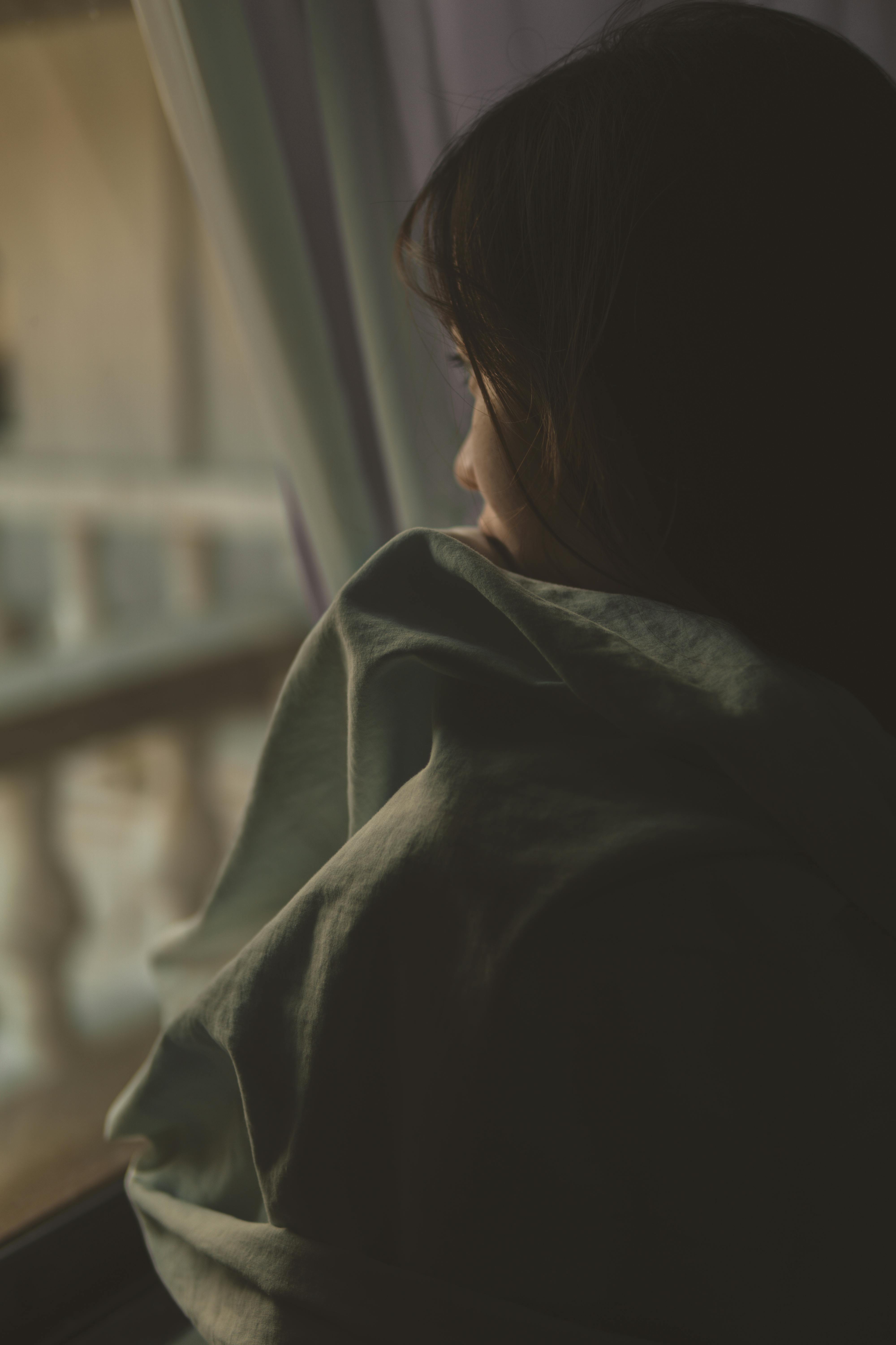 Une femme triste qui regarde par la fenêtre | Source : Pexels