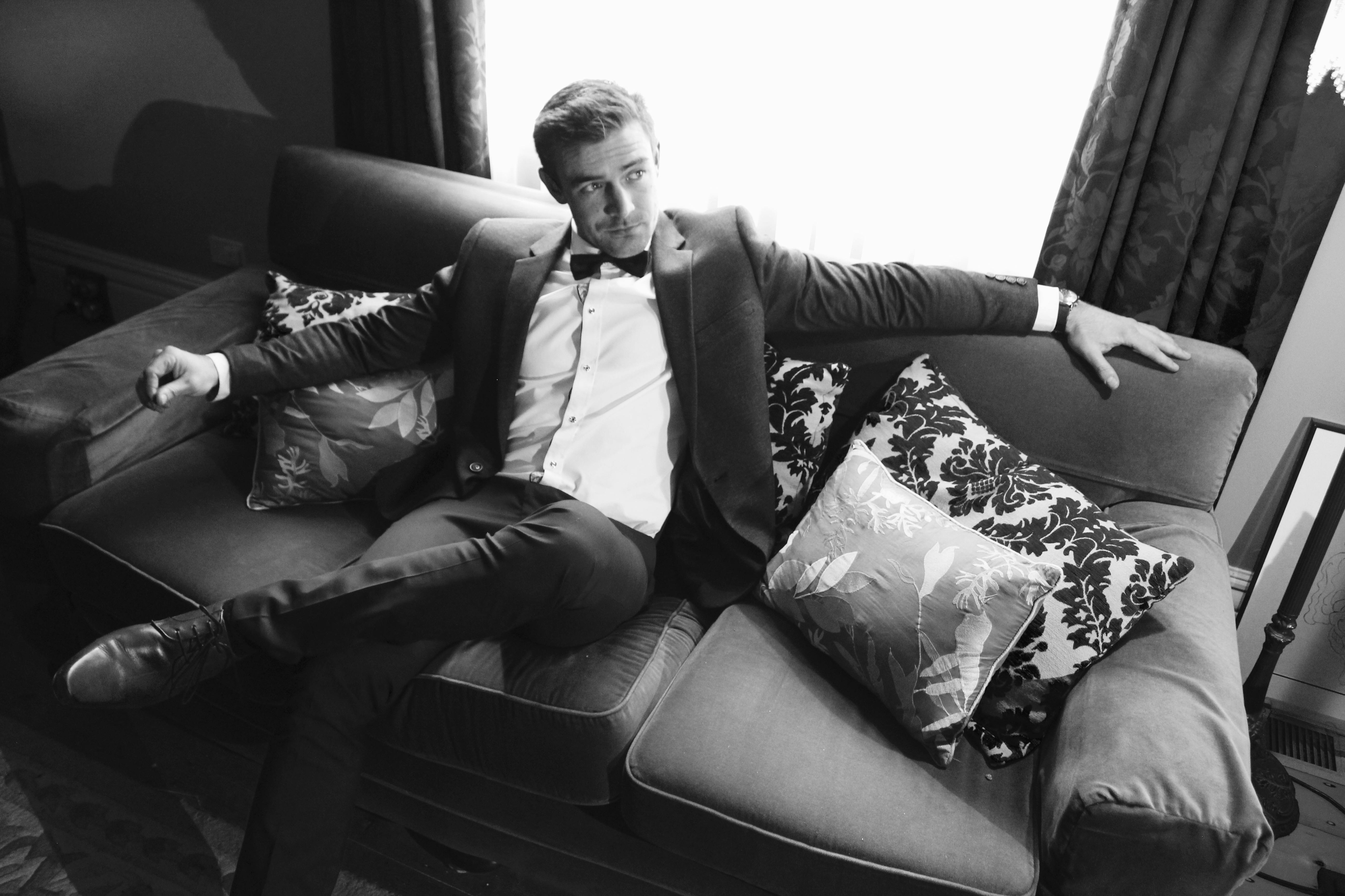 Homme en costume assis sur un canapé | Source : Pexels
