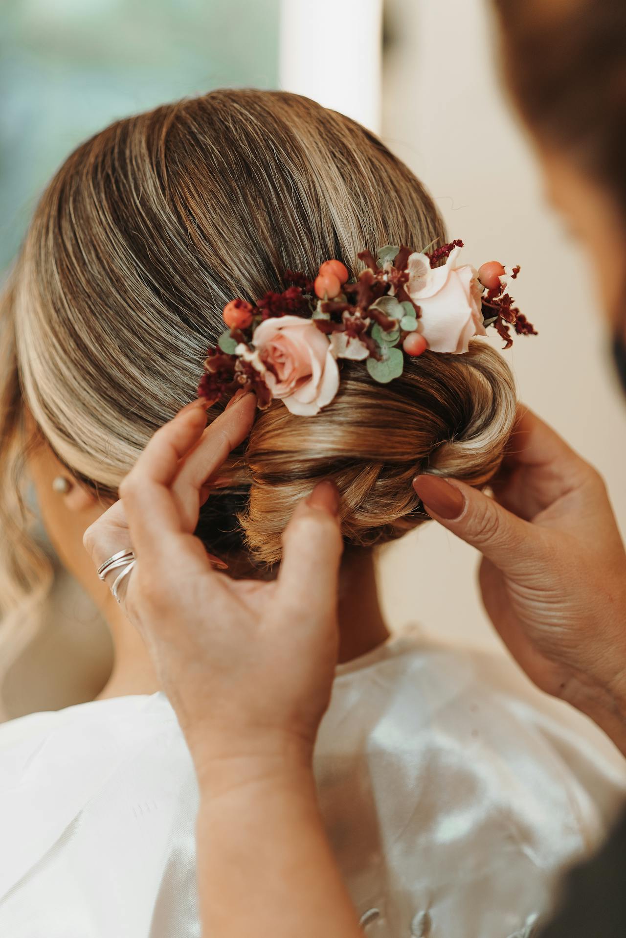 Une femme arrange les cheveux d'une mariée | Source : Pexels