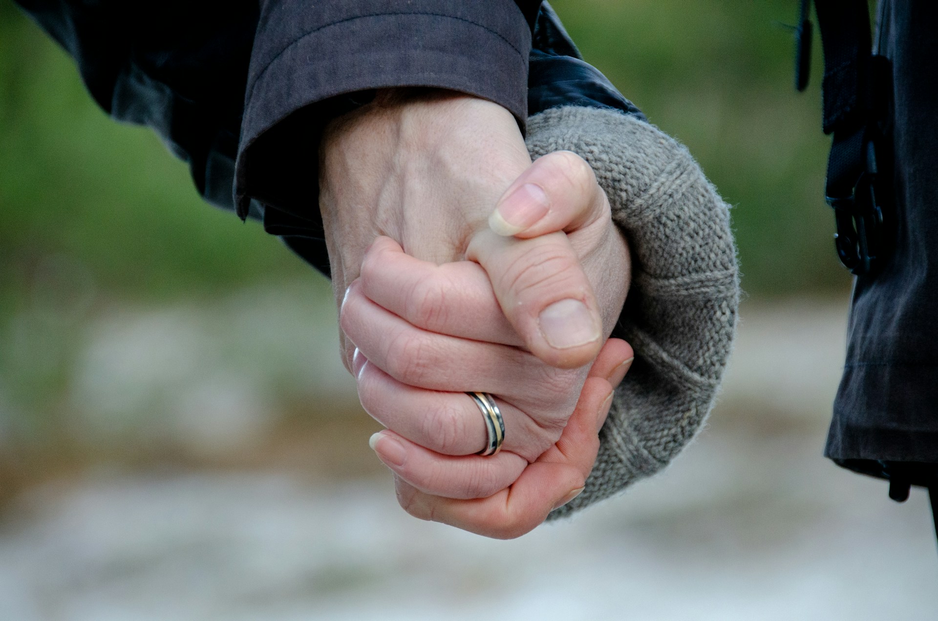 Gros plan d'un couple se tenant par la main | Source : Unsplash
