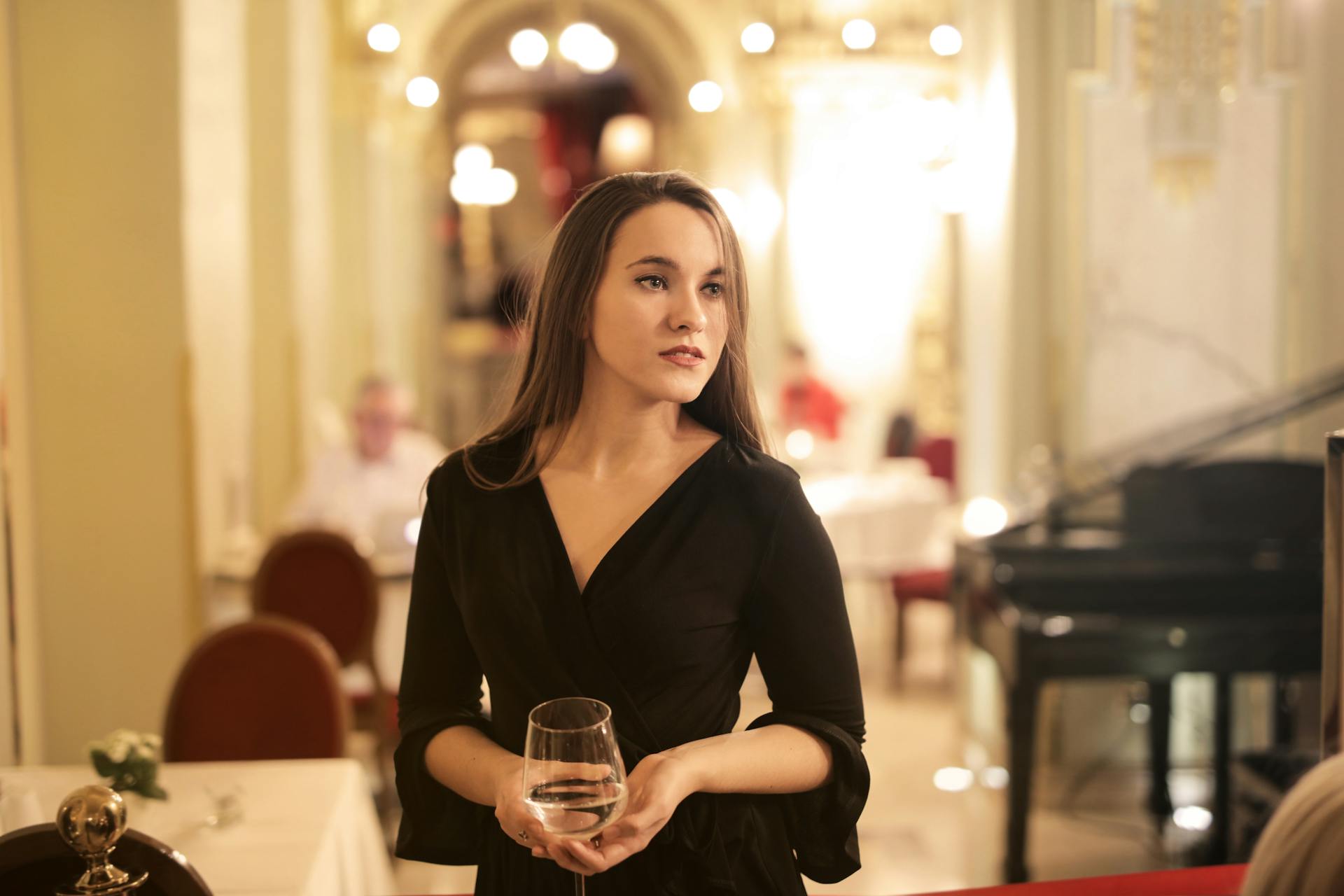 Une femme tenant un verre de boisson alors qu'elle se trouve dans un restaurant | Source : Pexels