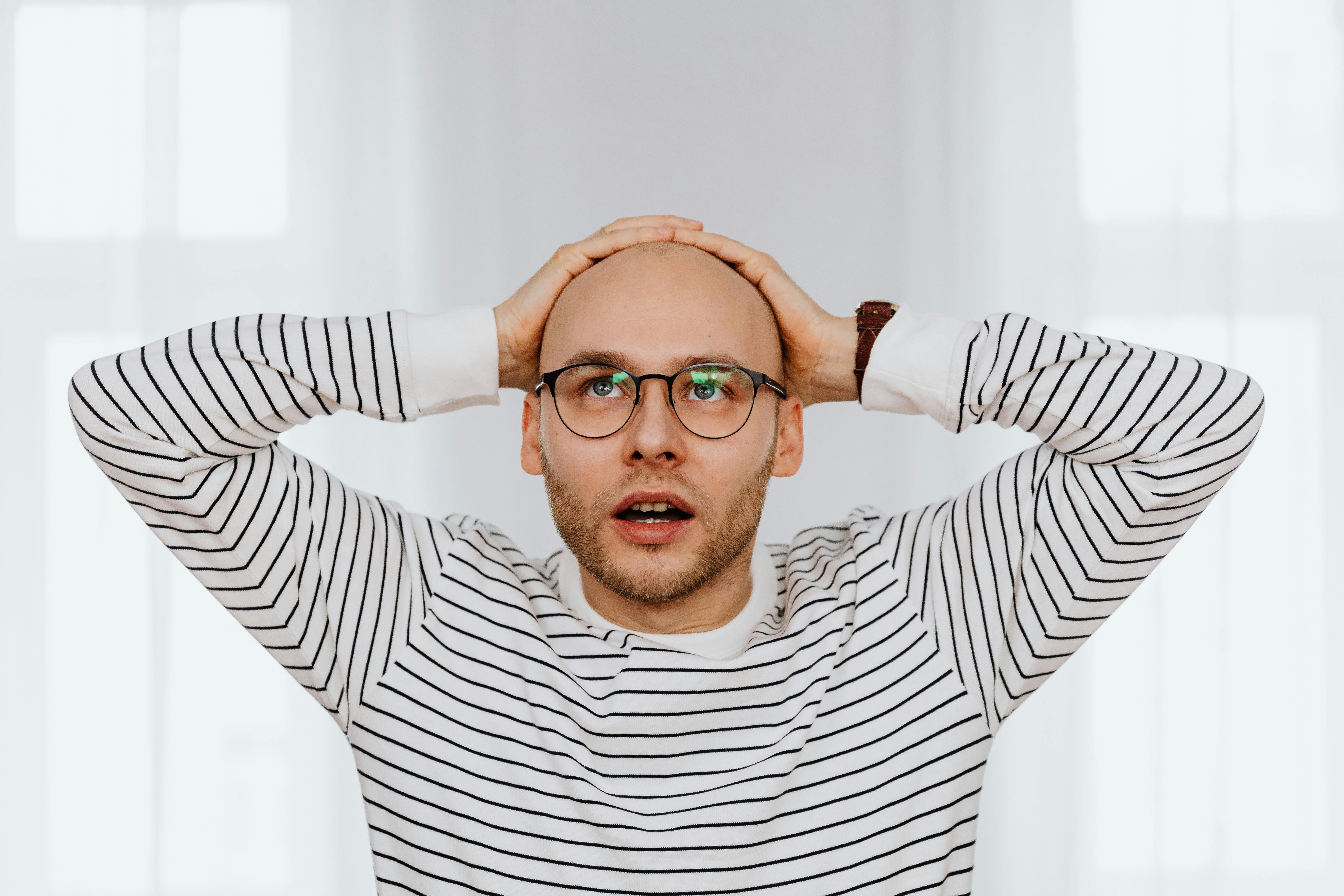 Un homme assis et se tenant la tête | Source : Pexels