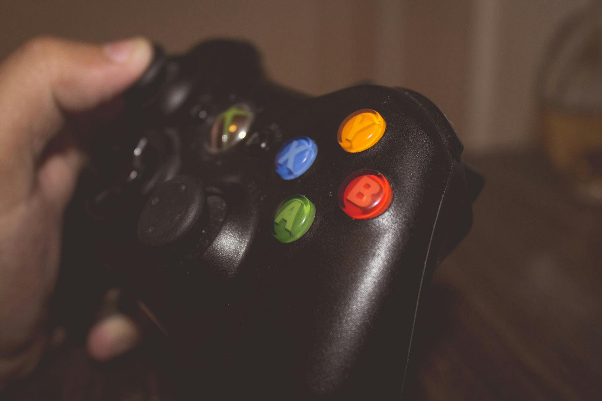 Une personne brandissant la télécommande d'une console de jeu | Source : Pexels