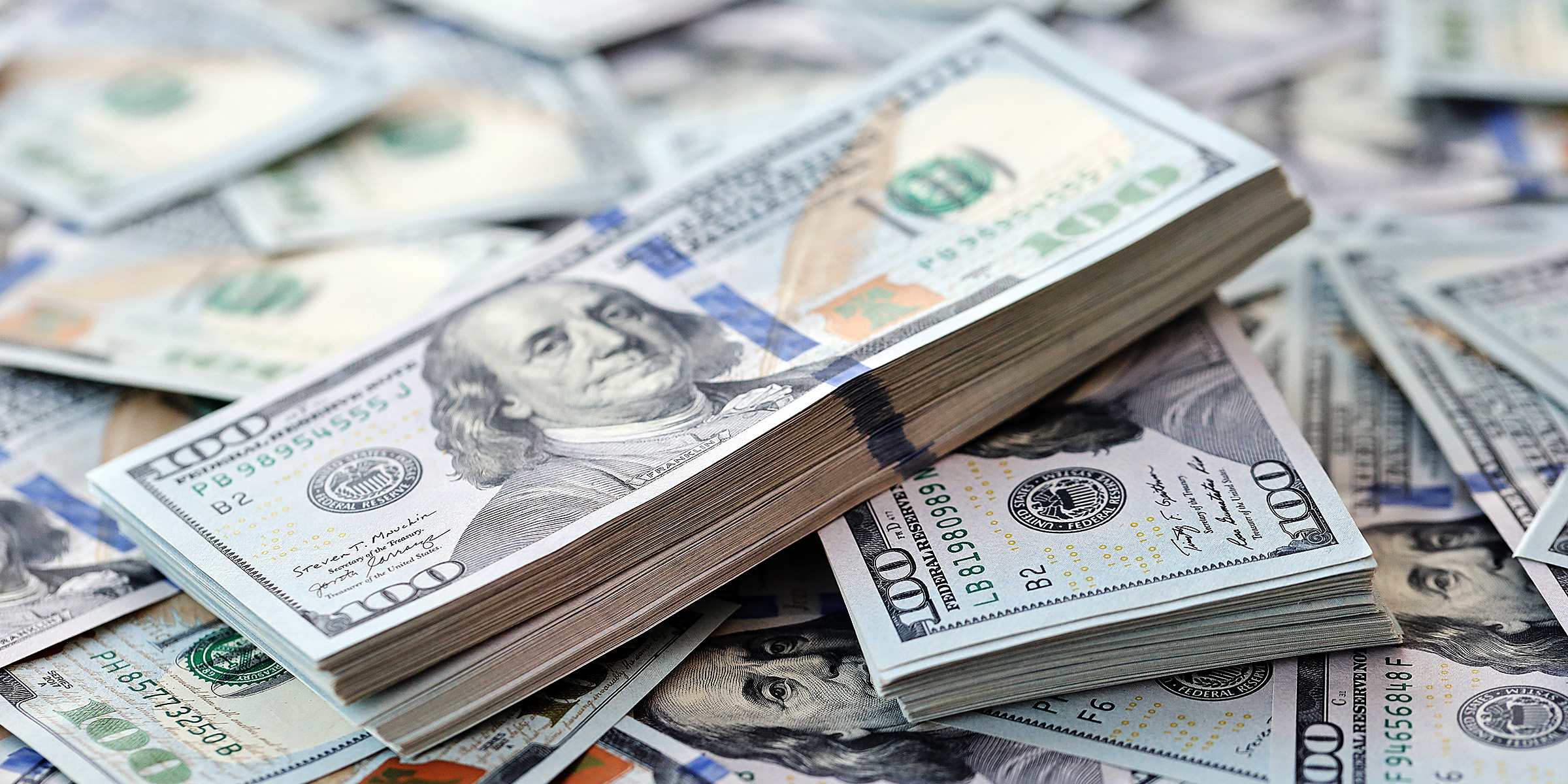 Gros plan sur des billets de cent dollars | Source : Shutterstock