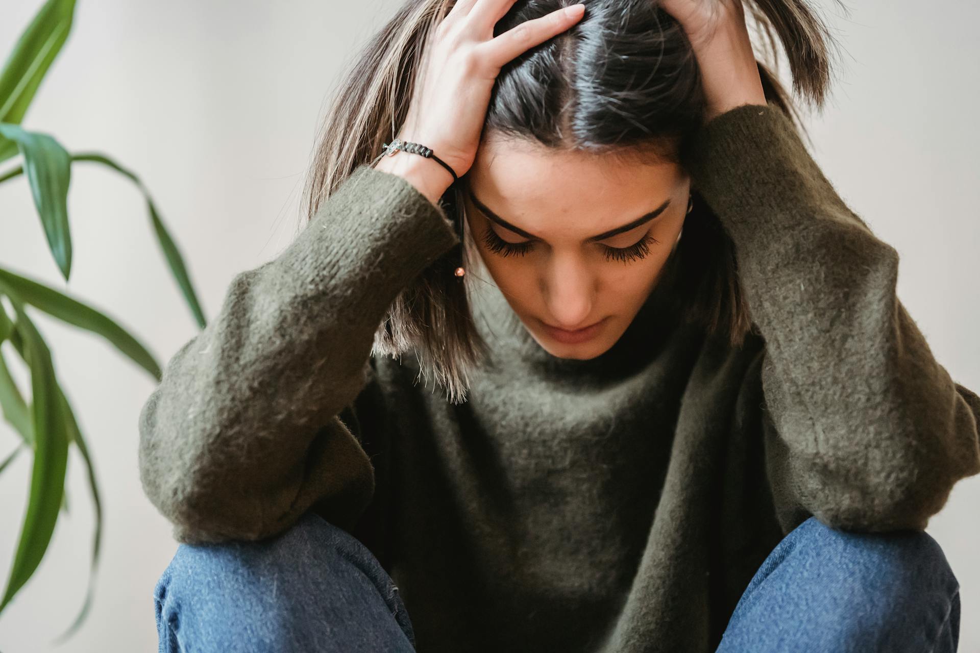 Une femme assise, la tête dans les mains | Source : Pexels
