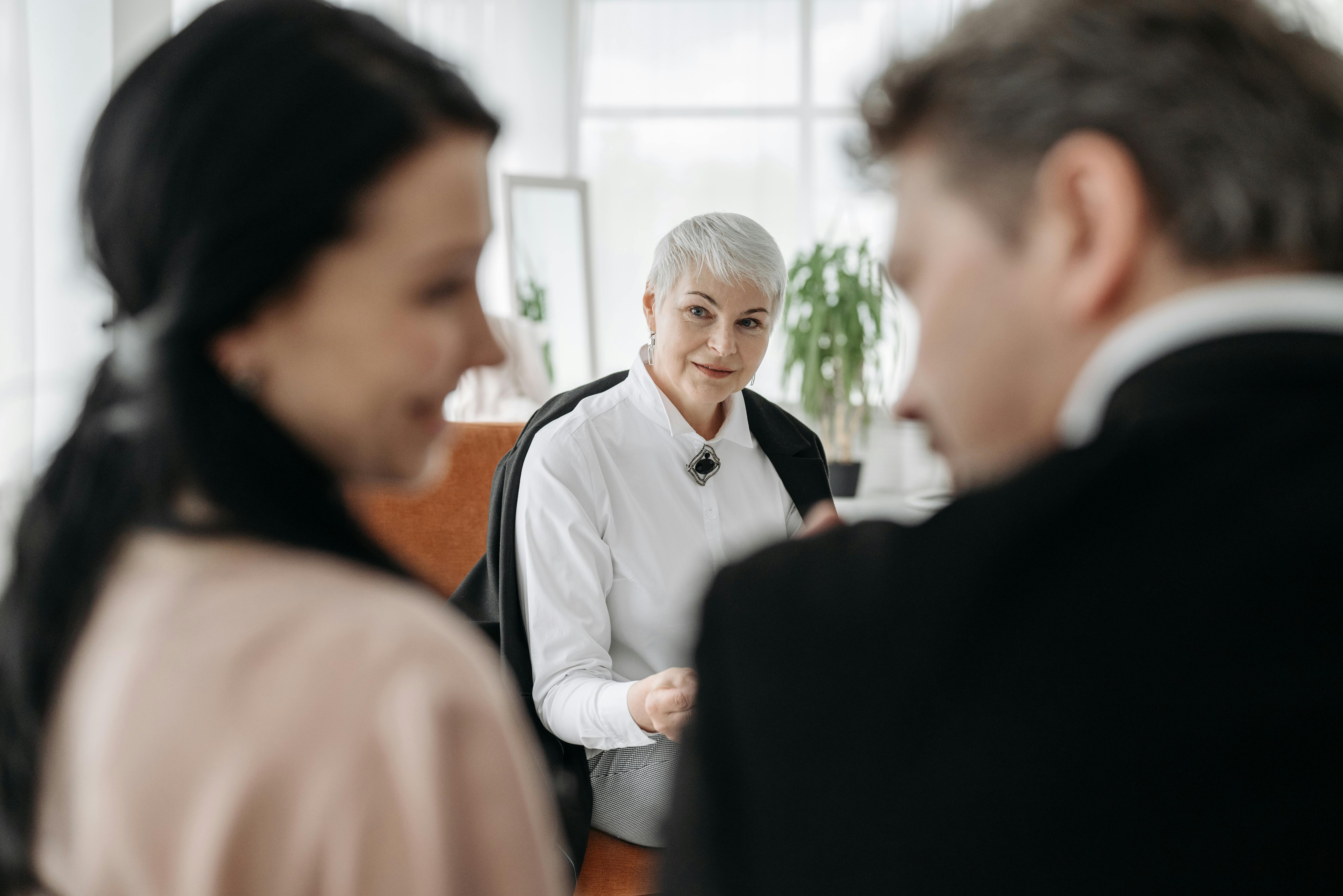 Jeune couple discutant avec une femme plus âgée | Source : Pexels