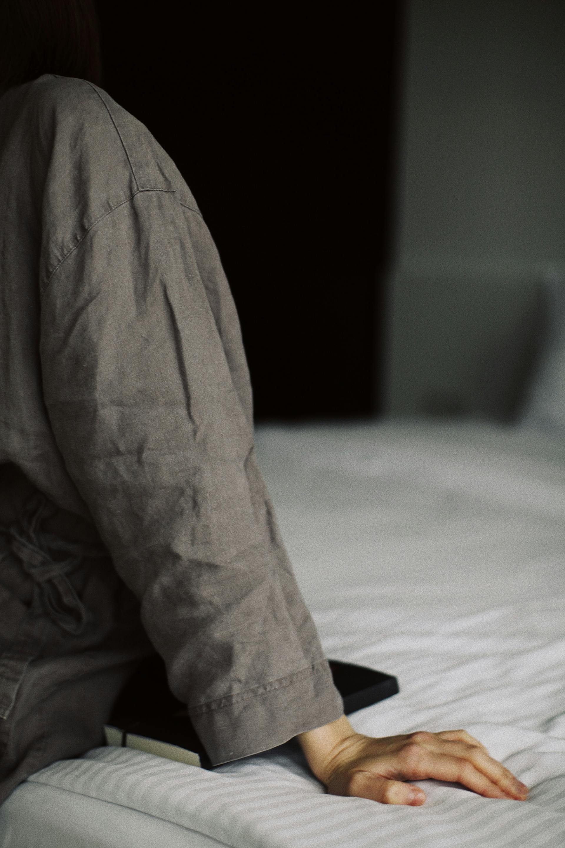 Gros plan sur une femme assise sur le lit | Source : Pexels