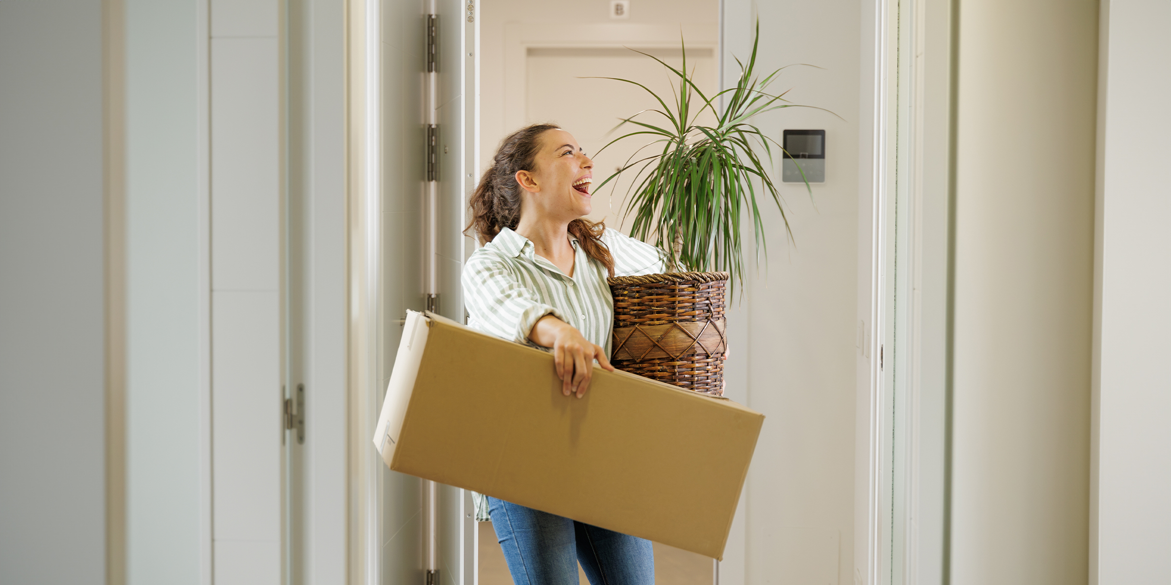 Une femme portant une boîte et une plante | Source : Shutterstock