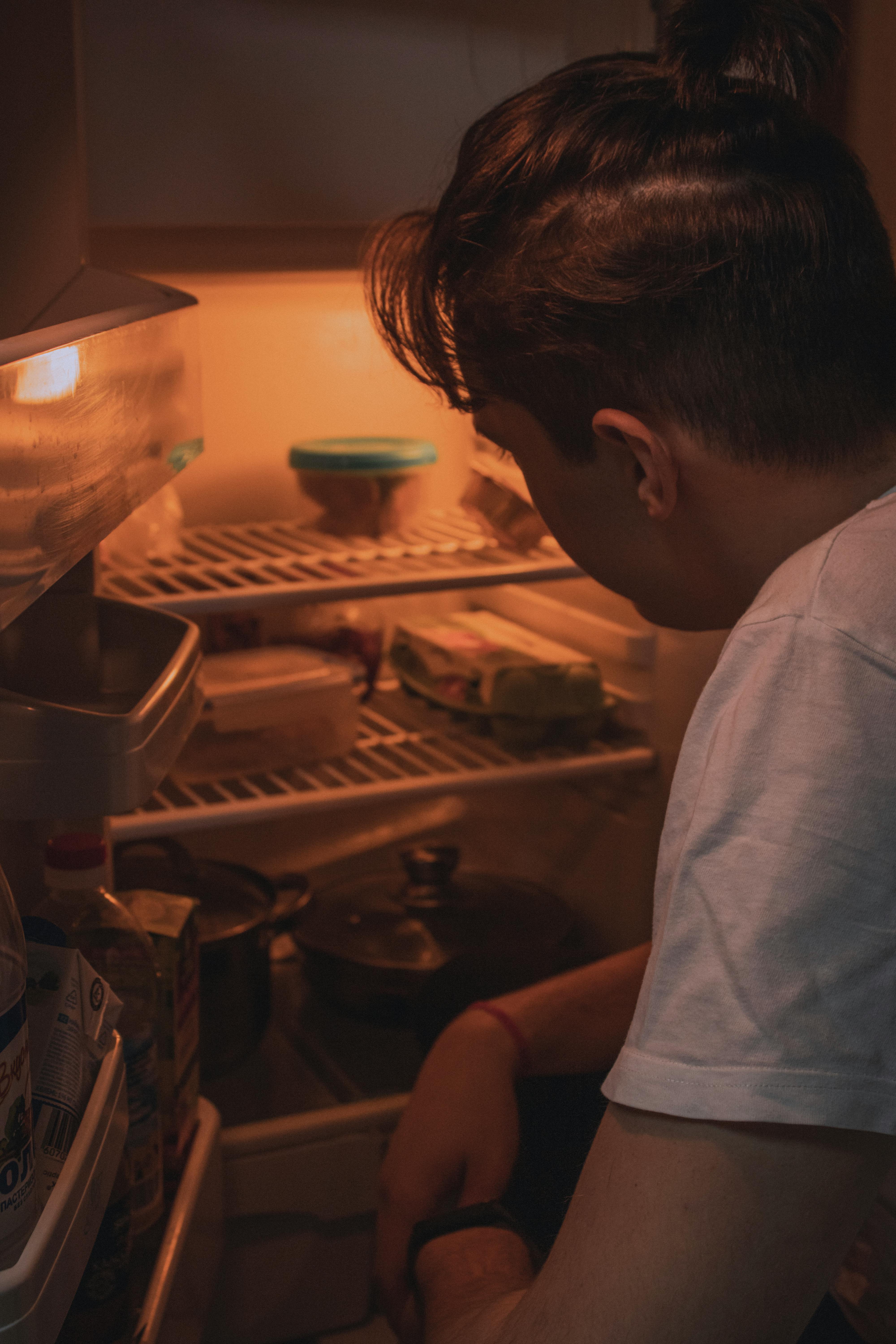 Un homme fouillant pour trouver quelque chose dans le réfrigérateur | Source : Pexels
