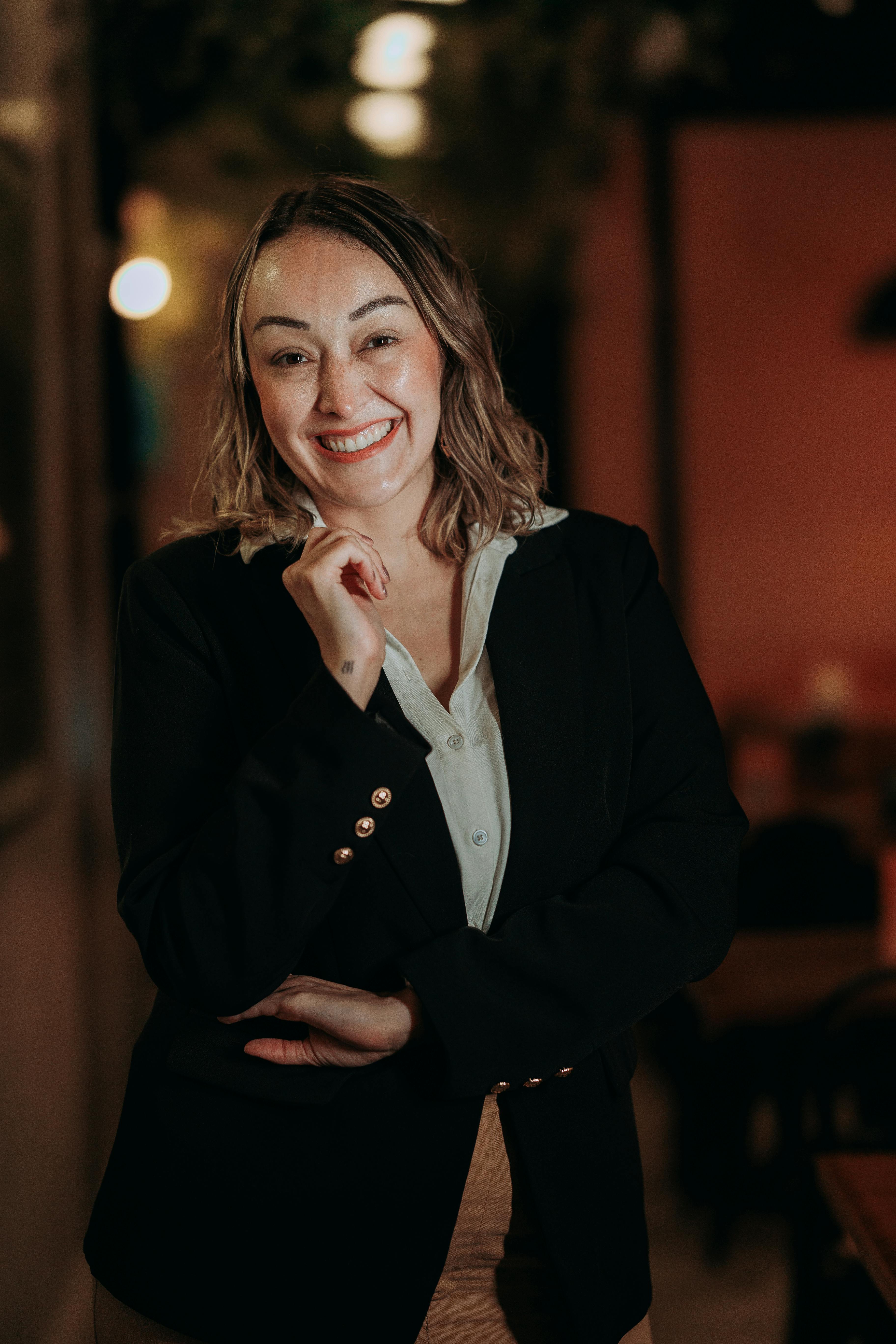 Une femme souriante debout dans un couloir d'hôtel | Source : Pexels