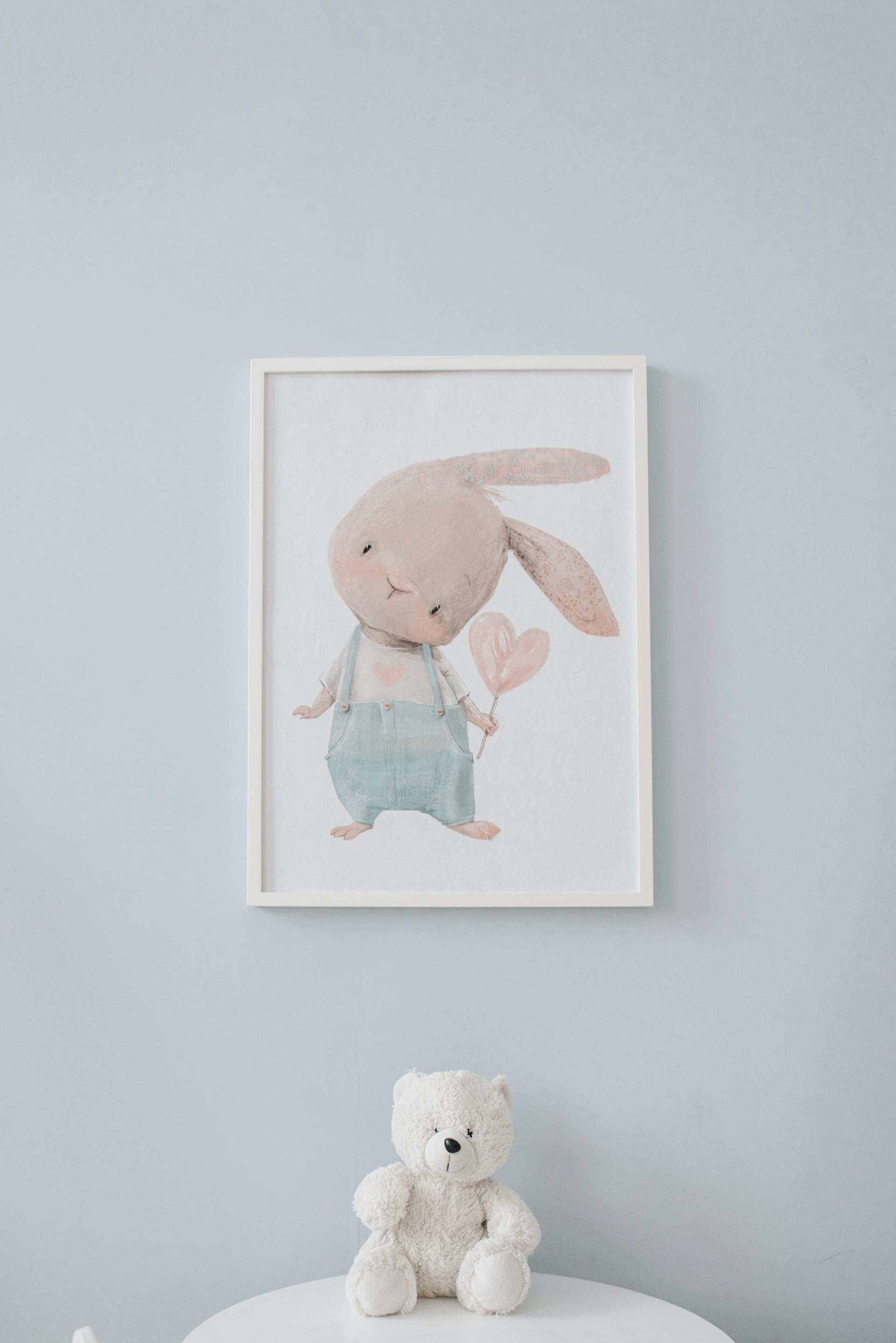 Un ours en peluche posé au pied d'un cadre mural | Source : Pexels