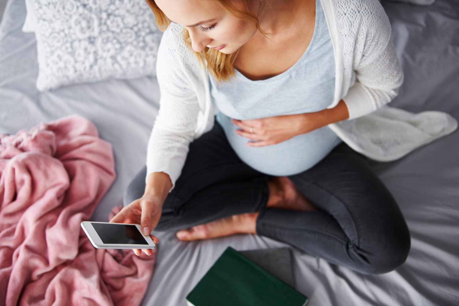 Une femme enceinte qui regarde son téléphone | Source : Freepik