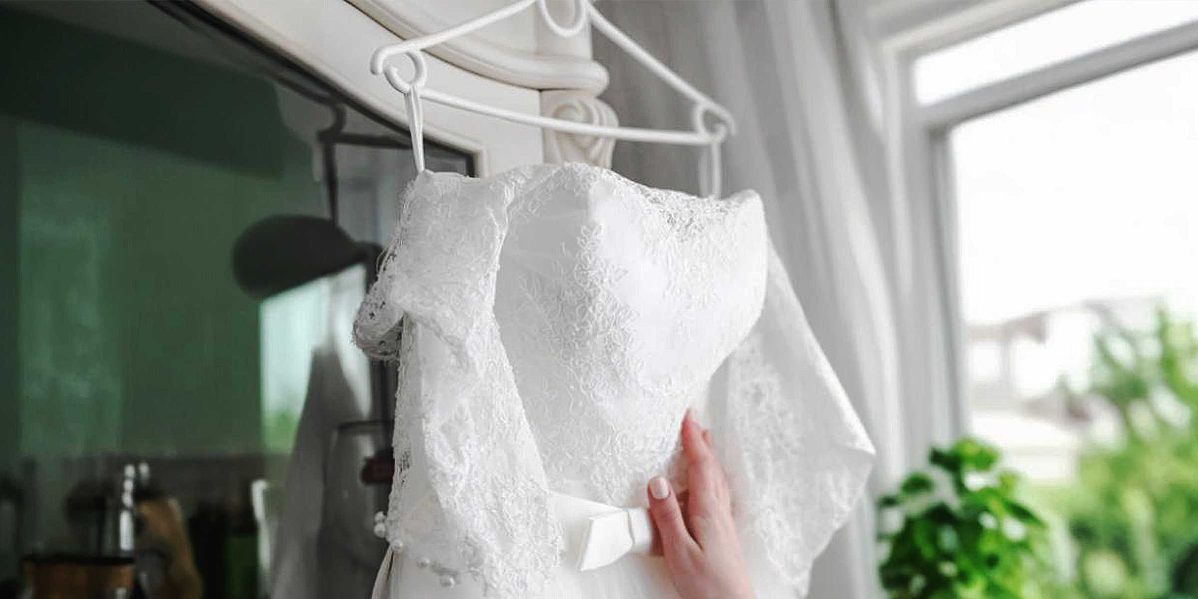 Une femme touche une robe de mariée | Source : Freepik
