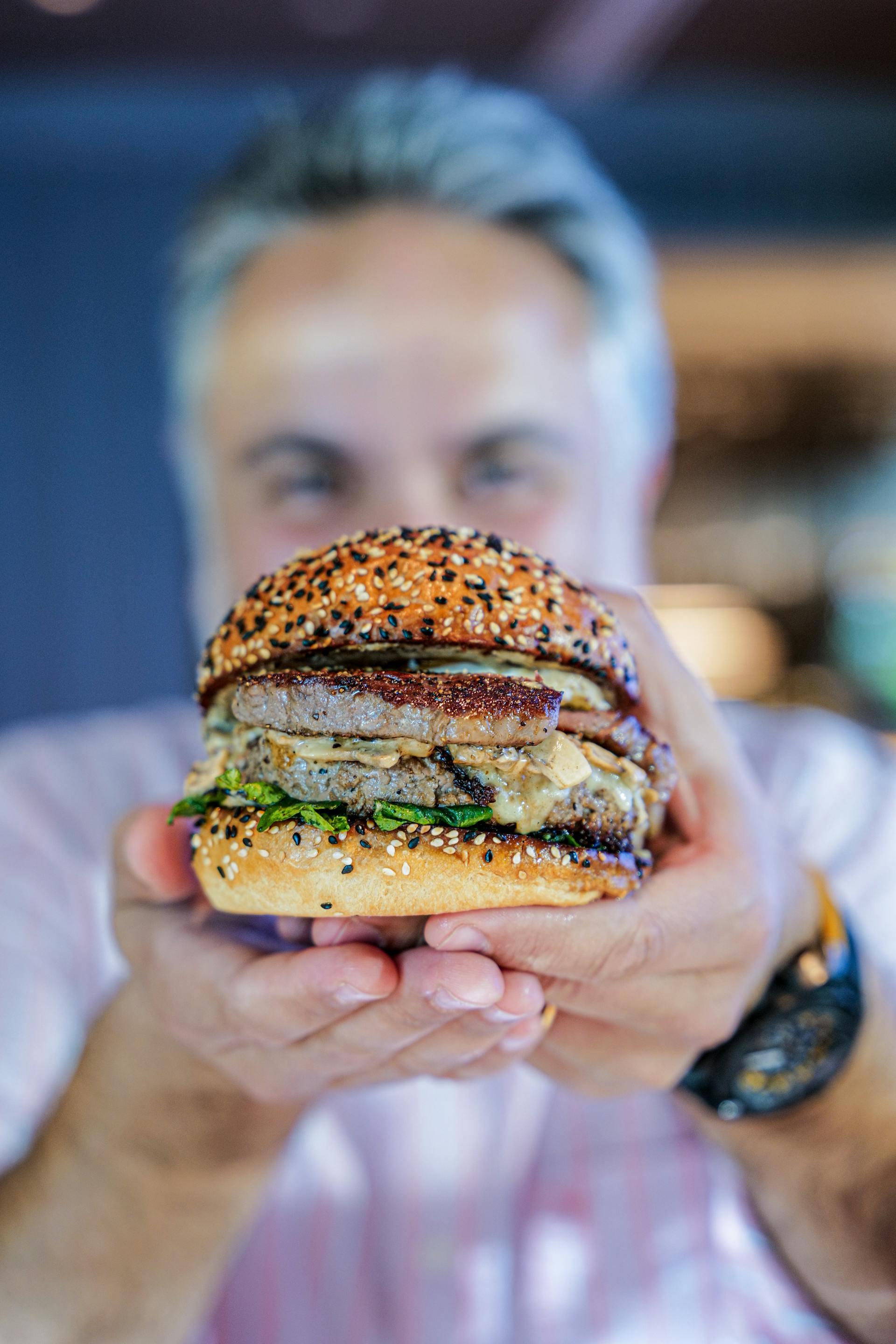 Un homme tenant un hamburger | Source : Pexels
