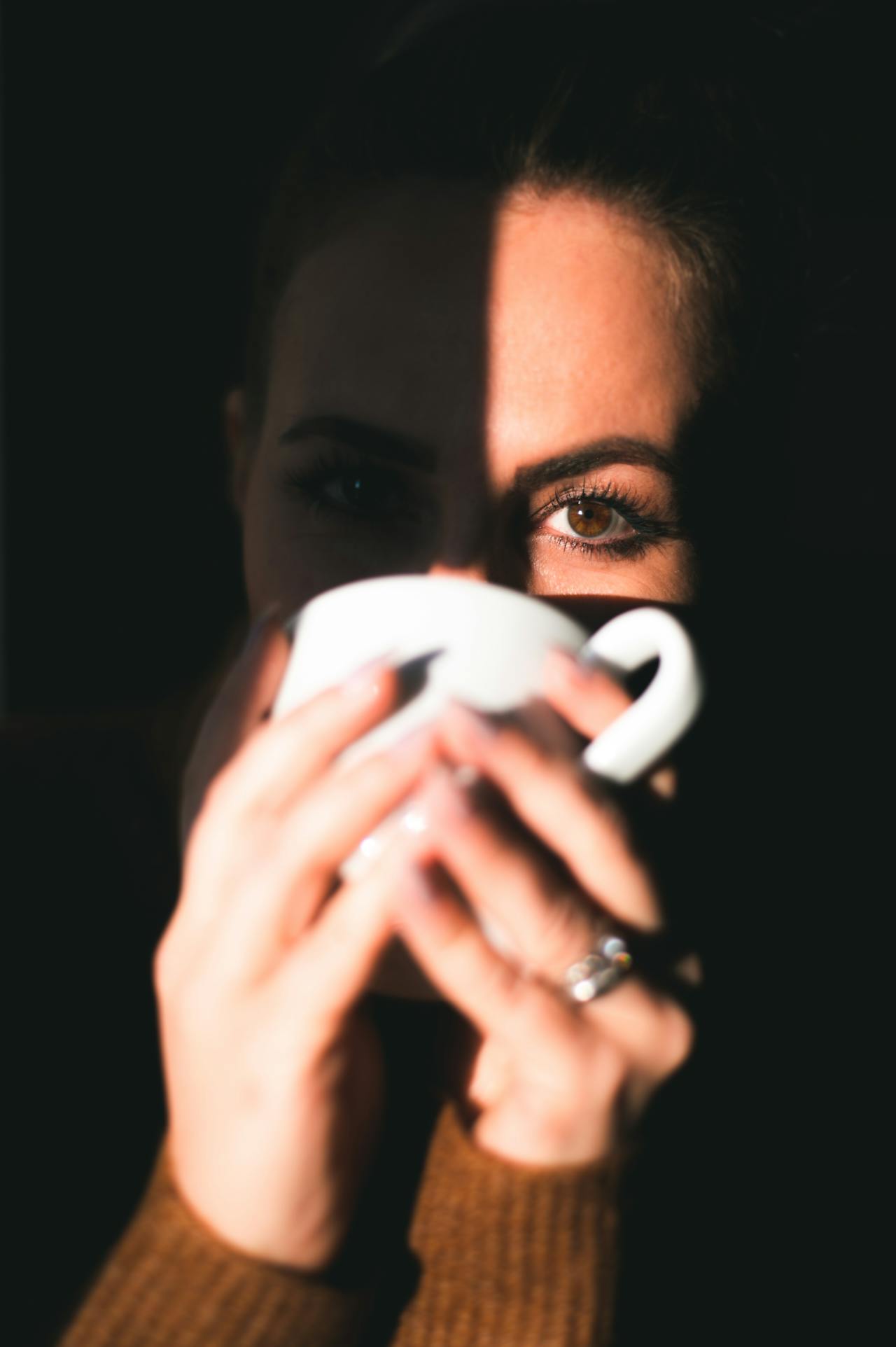 Une femme buvant une boisson dans une tasse en céramique | Source : Pexels