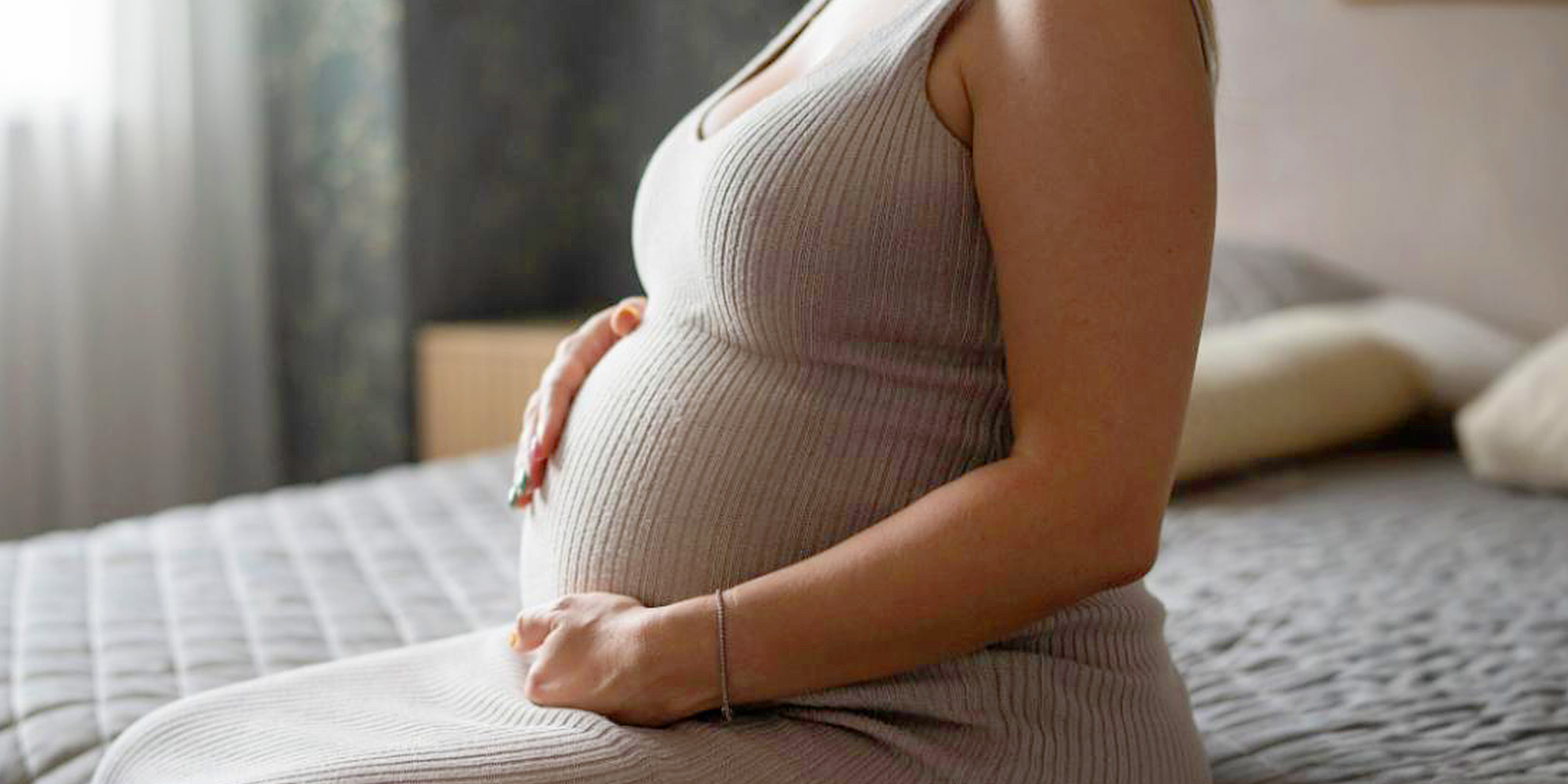 Une femme enceinte se tenant le ventre | Source : Freepik