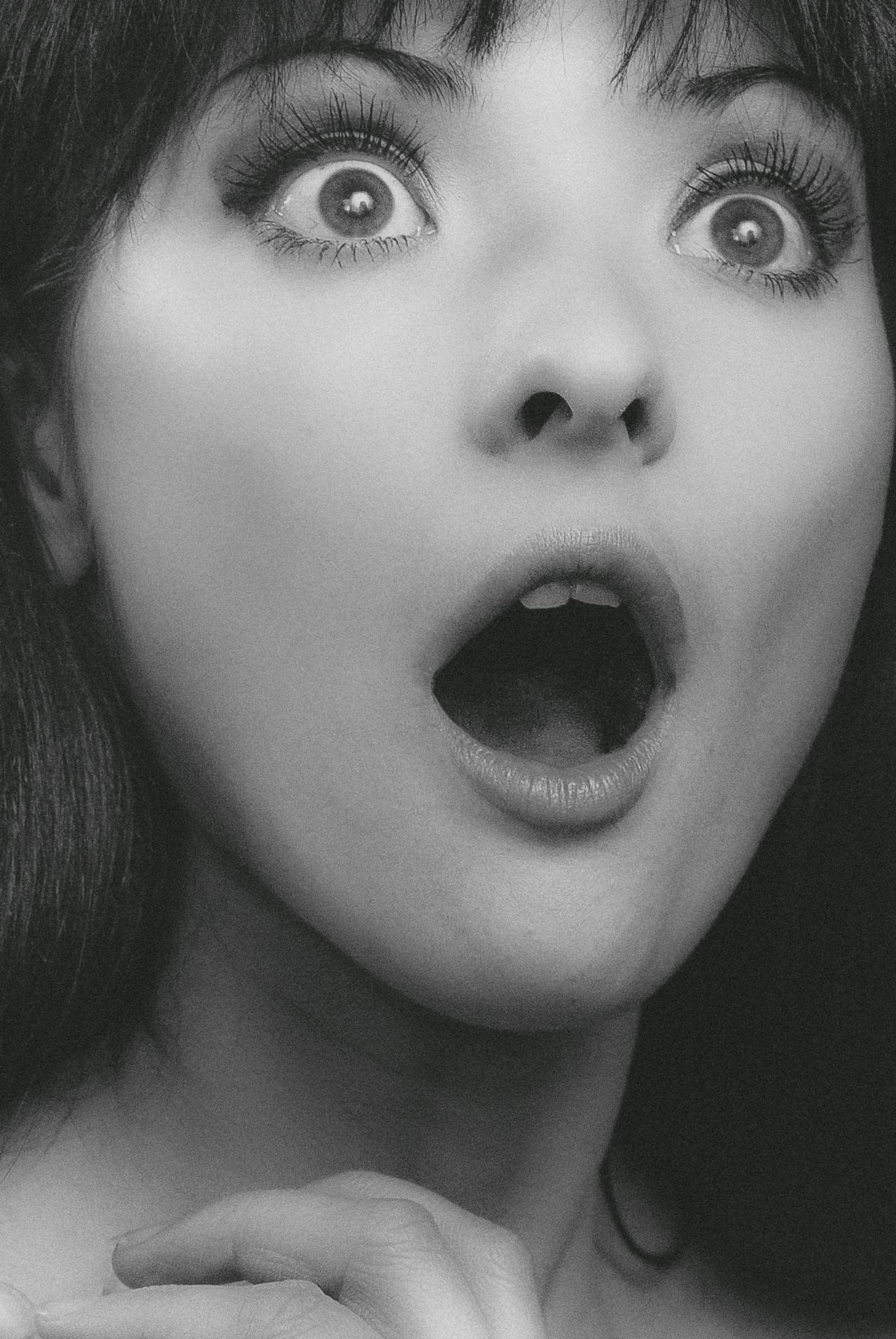 Photo en niveaux de gris d'une jeune femme choquée | Source : Pexels