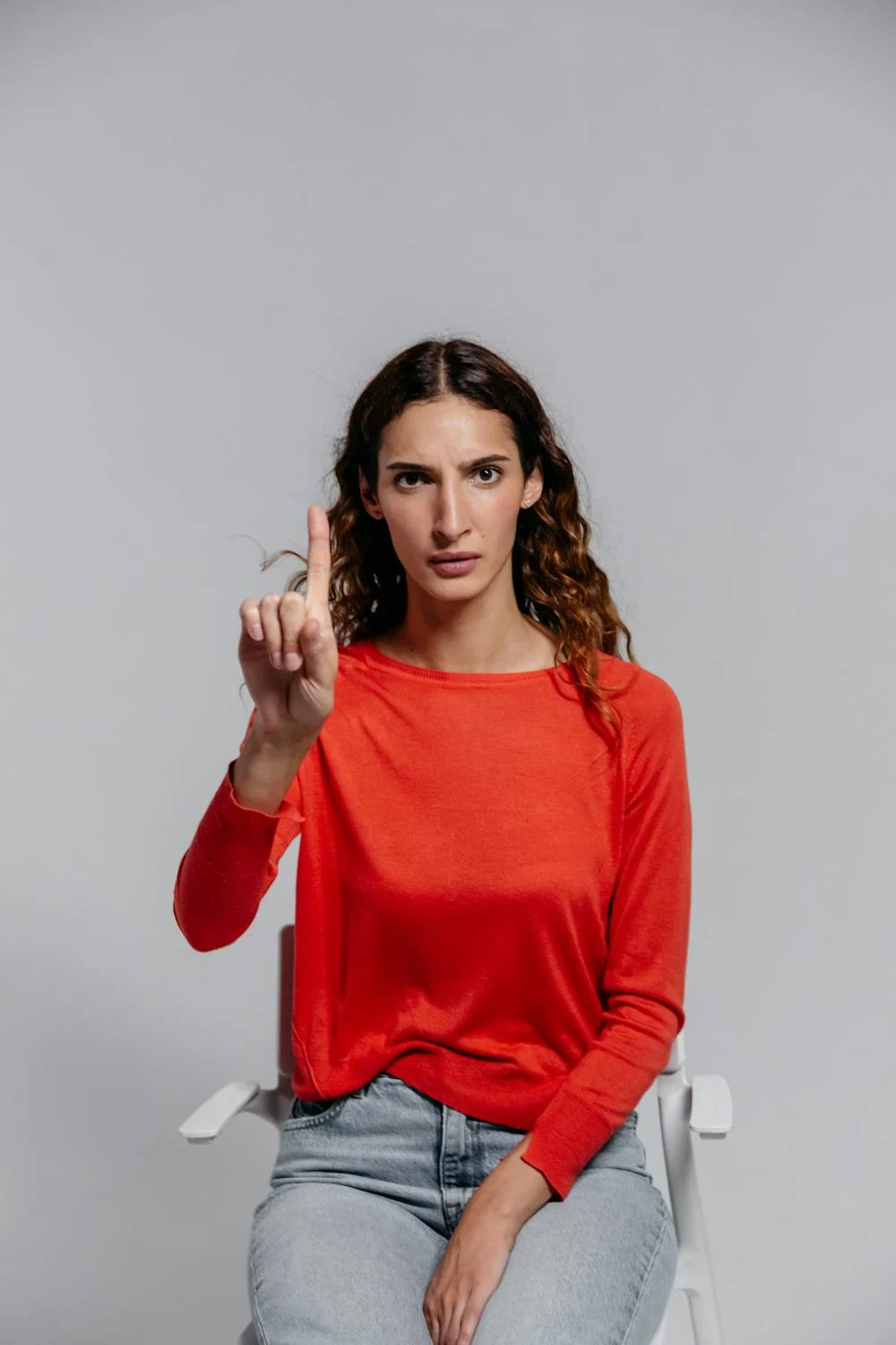 Une femme qui fronce les sourcils en levant le doigt | Source : Pexels