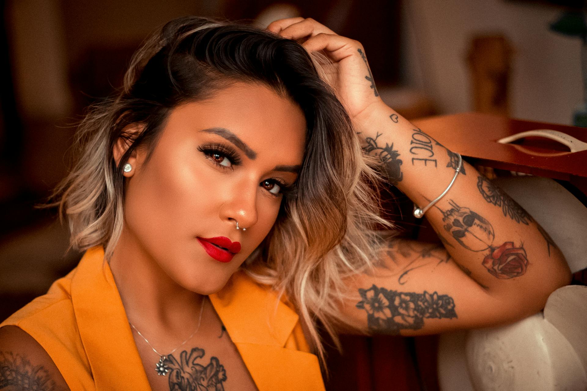 Une femme avec du rouge à lèvres rouge et des tatouages | Source : Pexels