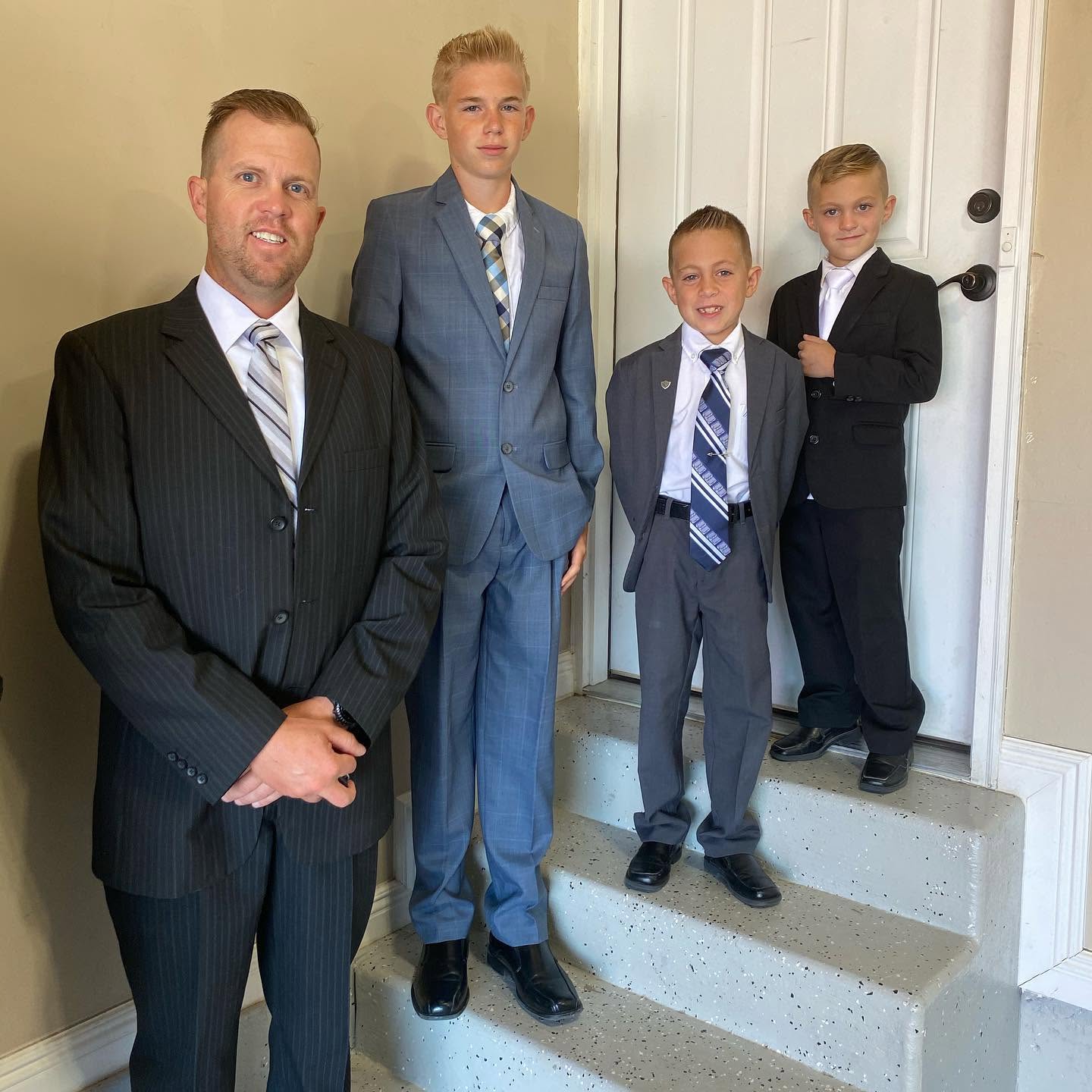 Spencer se tient au premier plan, les mains respectueusement jointes, posant à l'intérieur avec ses trois beaux fils, Reid, Thayne et Gage, sur un escalier tout proche. Le quatuor a l'air soudé et élégant dans ses costumes sur mesure, incarnant un héritage de force et d'unité. | Source : Facebook/katrina.g.long