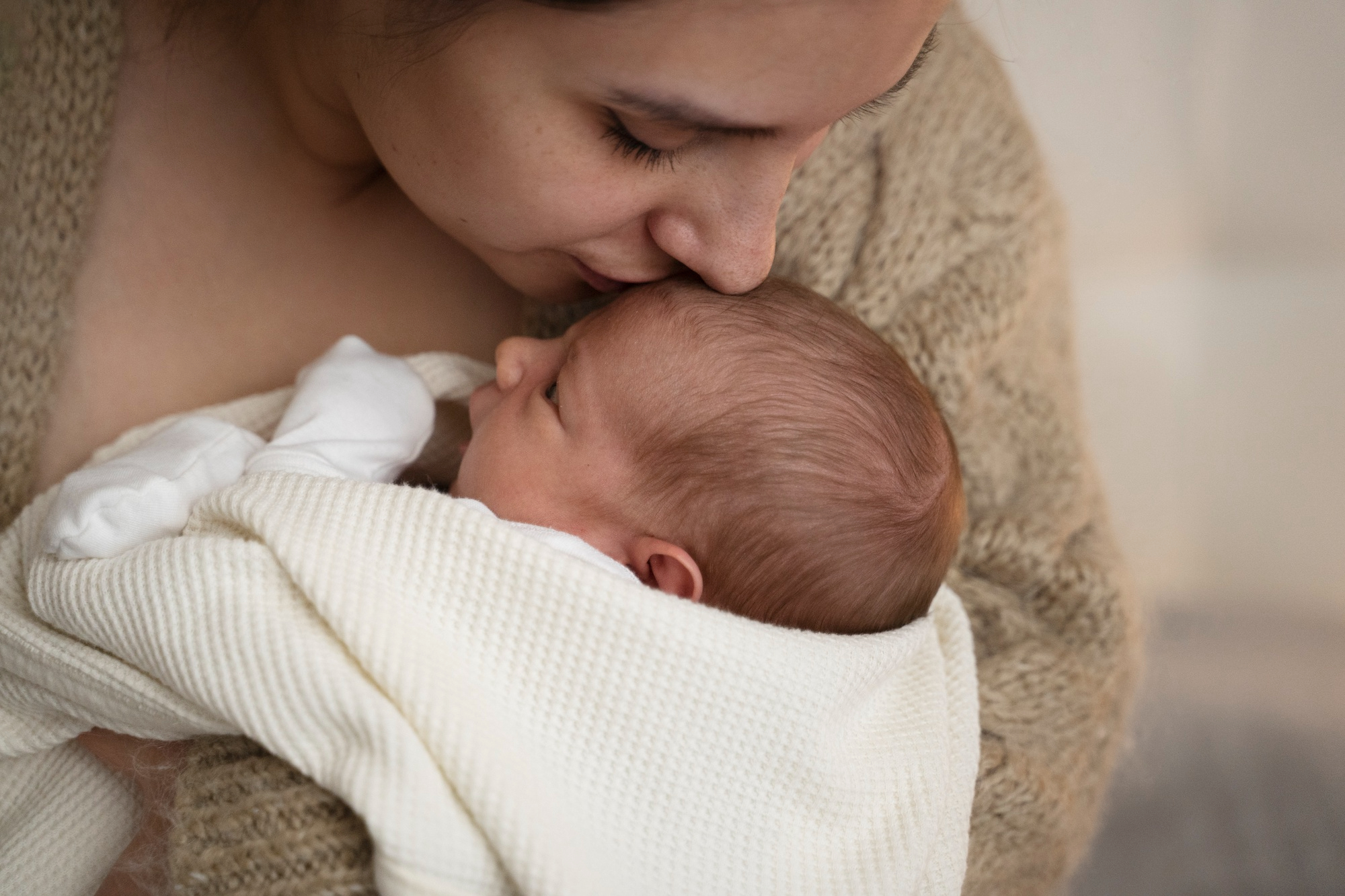Une femme embrasse son bébé | Source : Freepik