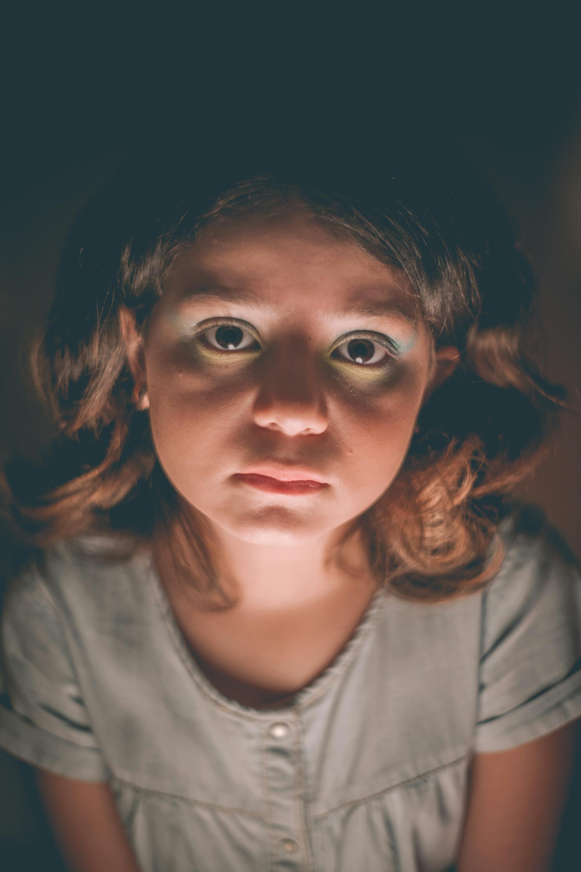 Une fille triste dans une pièce sombre | Source : Pexels