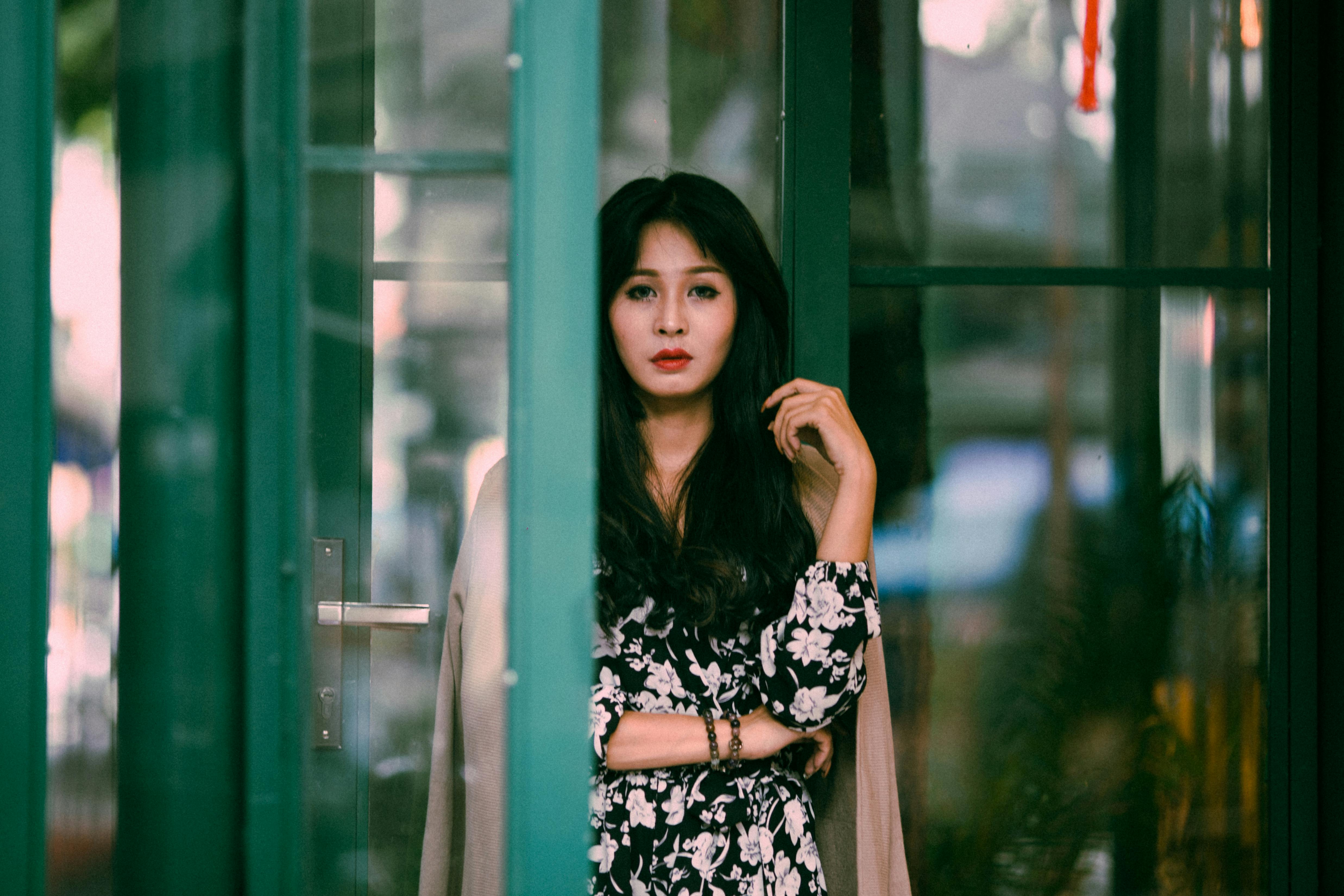 Une femme avec une attitude debout près d'une porte ouverte | Source : Pexels