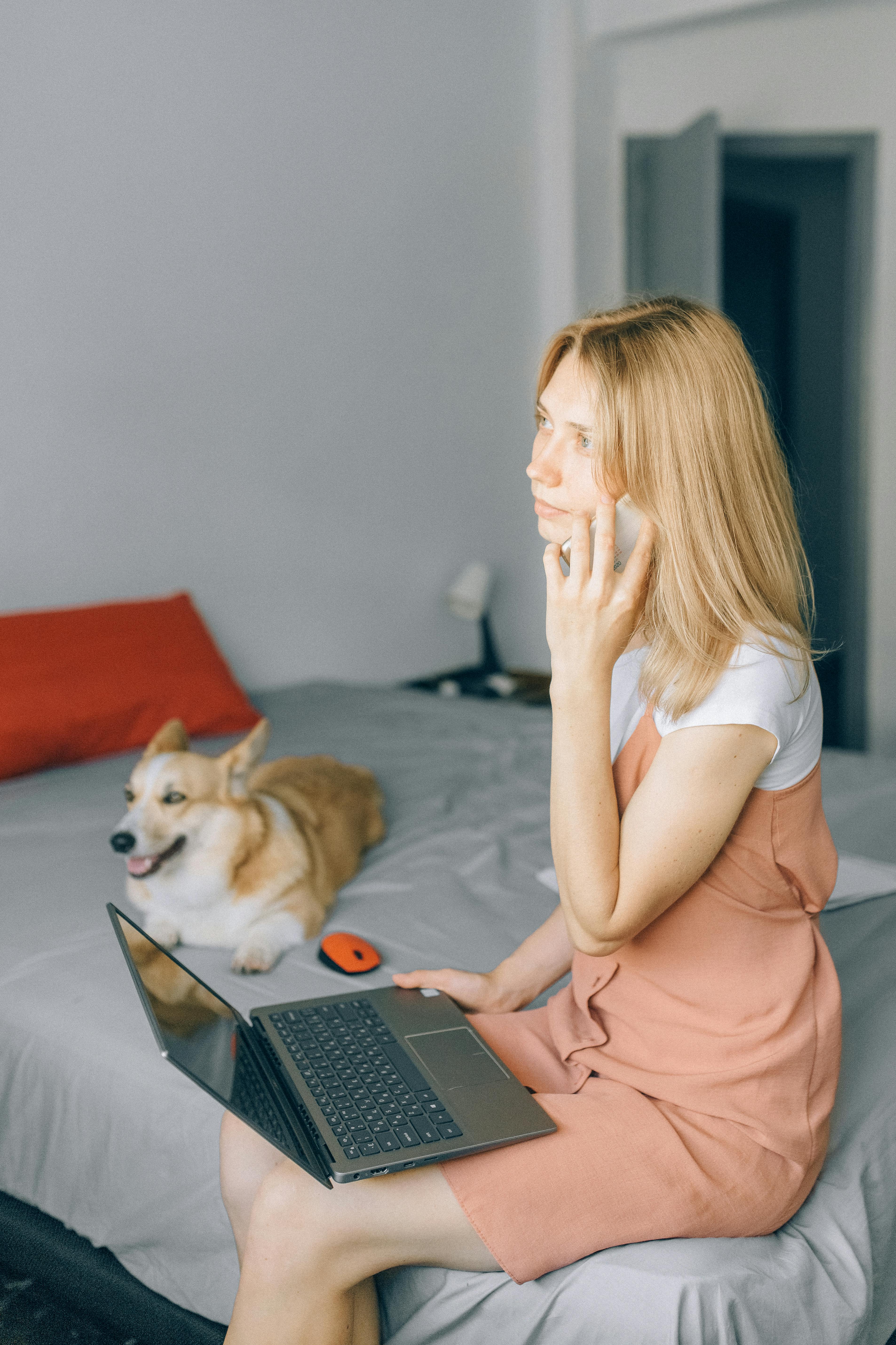 Femme assise sur le lit tout en parlant au téléphone | Source : Pexels