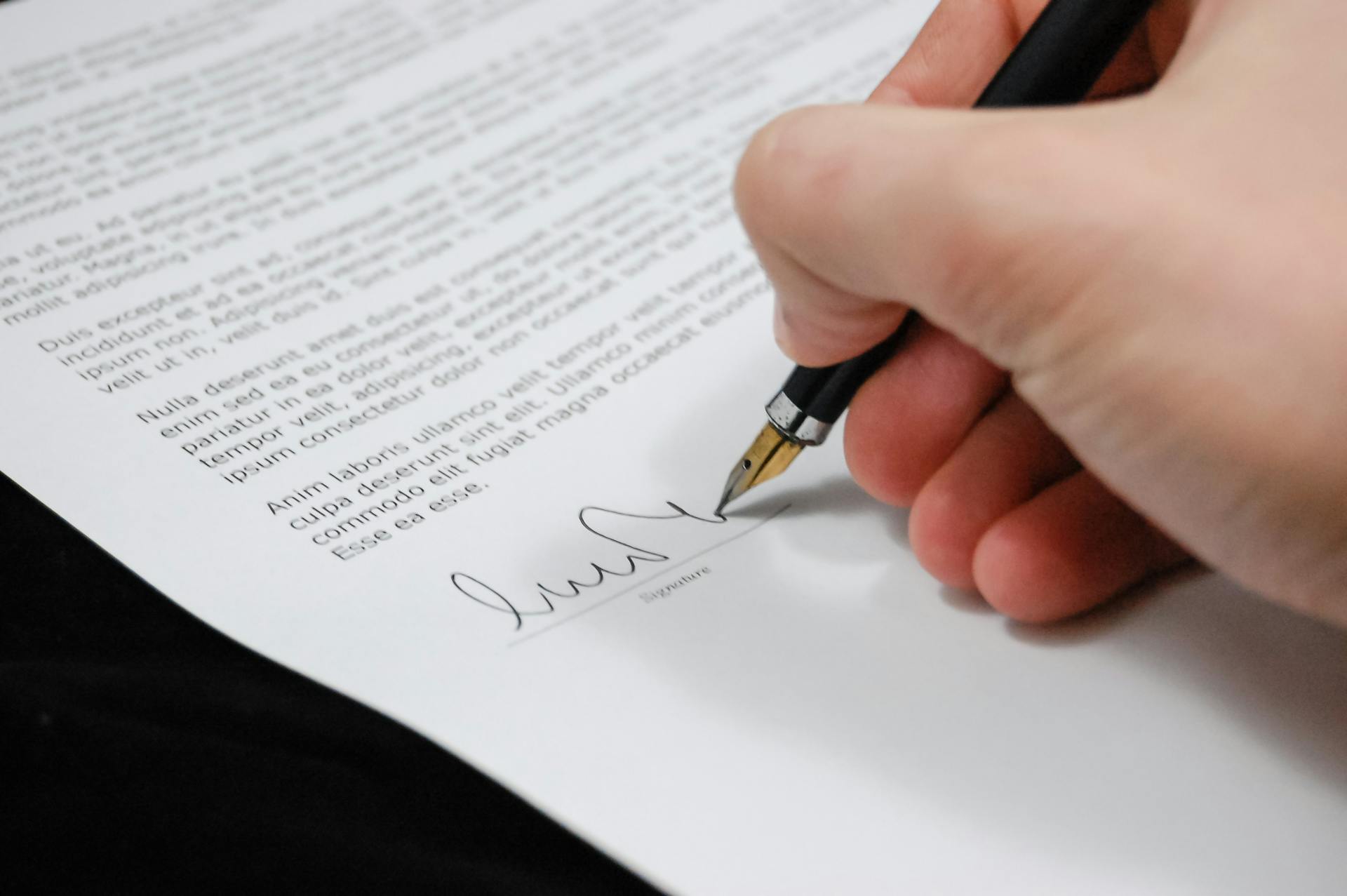 Un homme signant un document | Source : Pexels