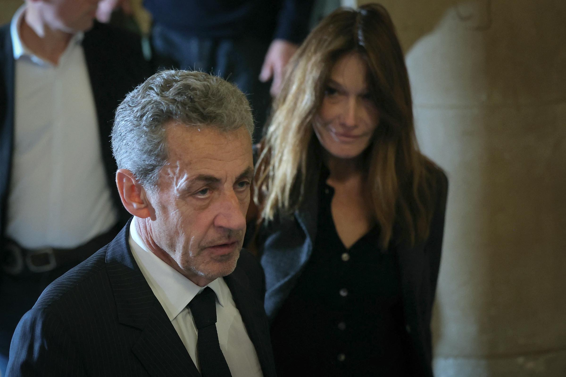 L'ancien président français Nicolas Sarkozy (à gauche) et son épouse Carla Bruni-Sarkozy quittent la salle d'audience après une suspension d'audience lors de son procès en appel concernant les accusations selon lesquelles il aurait sollicité un financement libyen pour sa campagne électorale de 2007, au Palais de Justice de Paris, le 7 avril 2026 I Source : Getty Images