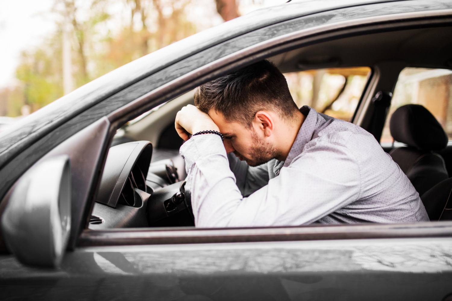 Un homme en détresse assis dans sa voiture | Source : Freepik