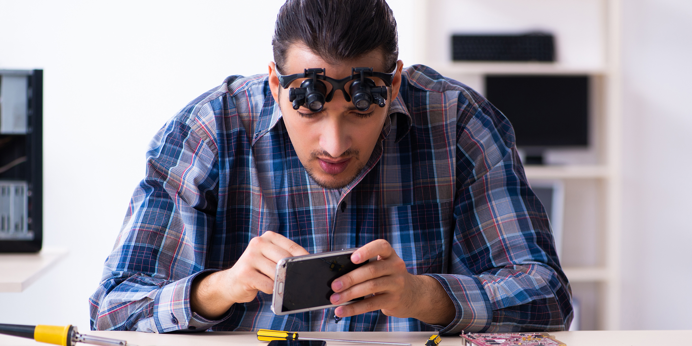 Un technicien qui répare un téléphone intelligent | Source : Shutterstock