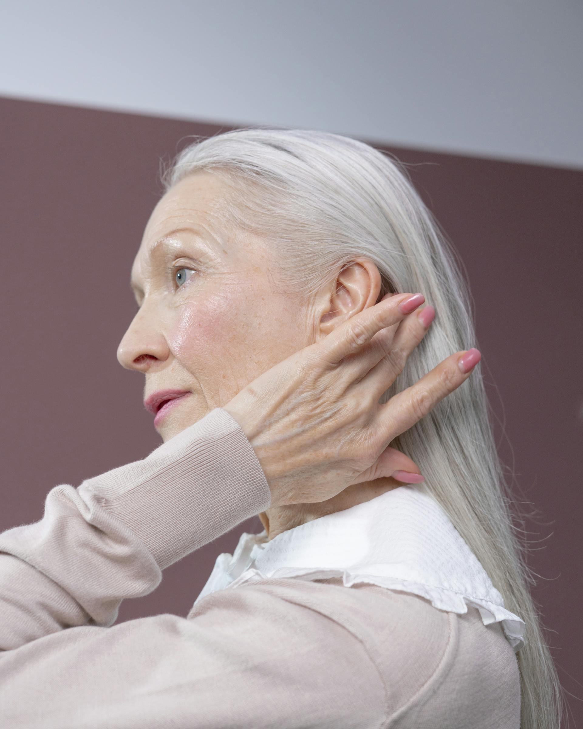 Une femme âgée au regard déterminé se touchant les cheveux | Source : Pexels