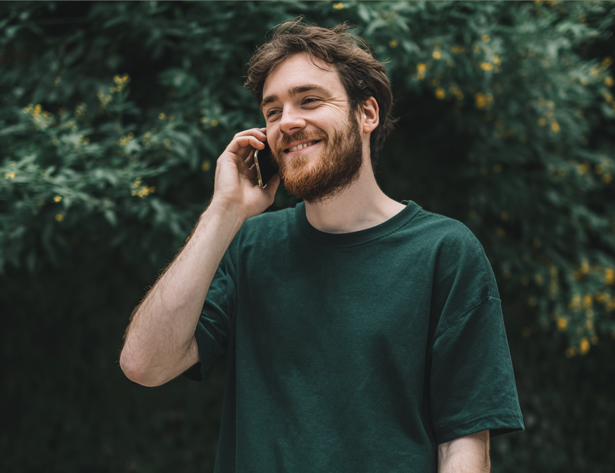 Un homme souriant qui parle au téléphone | Source : Midjourney