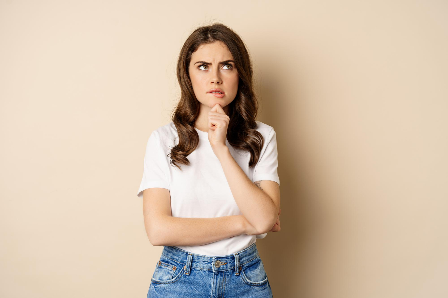 Une femme sérieuse perdue dans ses pensées | Source : Freepik