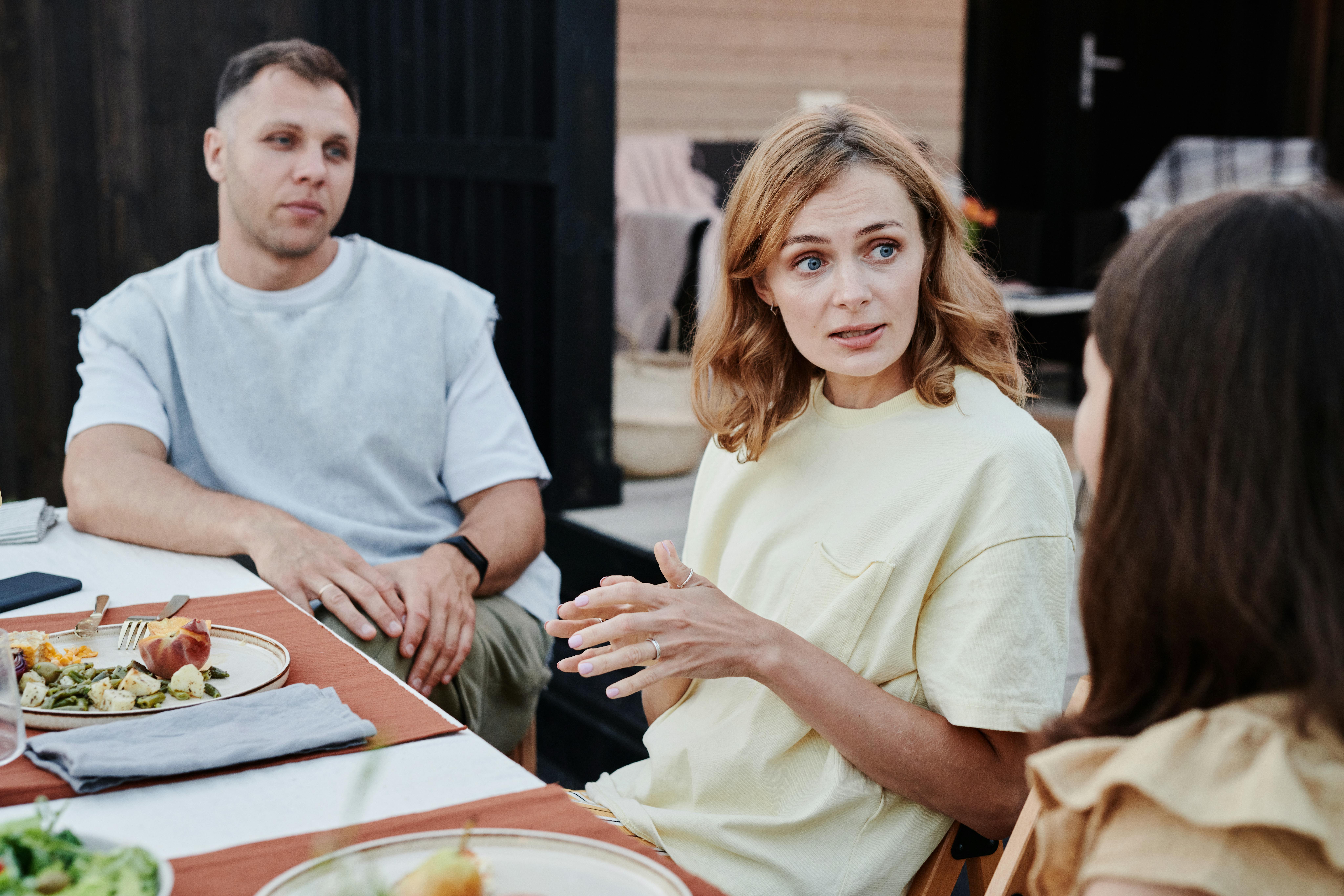 Un homme et deux femmes discutant à une table | Source : Pexels