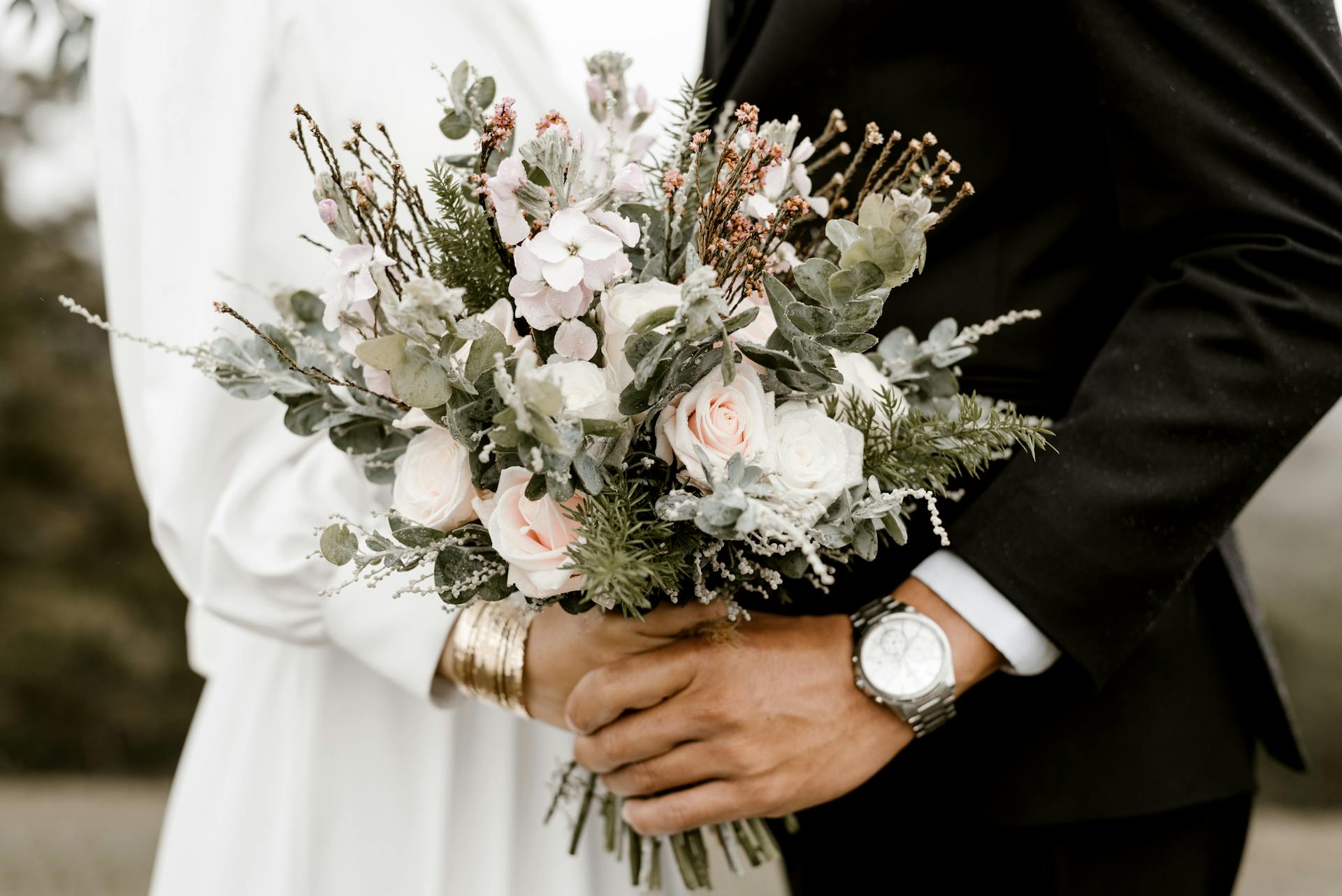 Gros plan d'une mariée et d'un marié tenant un bouquet | Source : Pexels