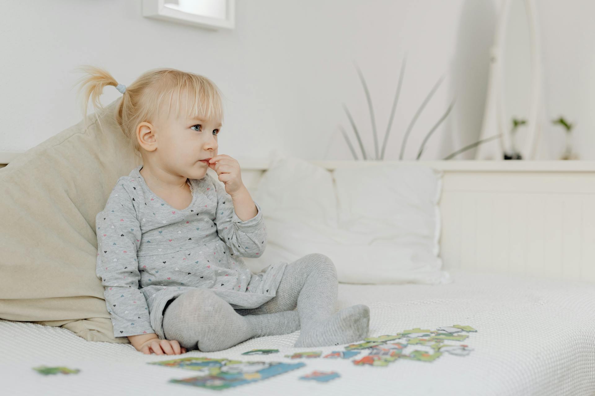 Une petite fille assise seule en train de jouer avec un puzzle | Source : Pexels