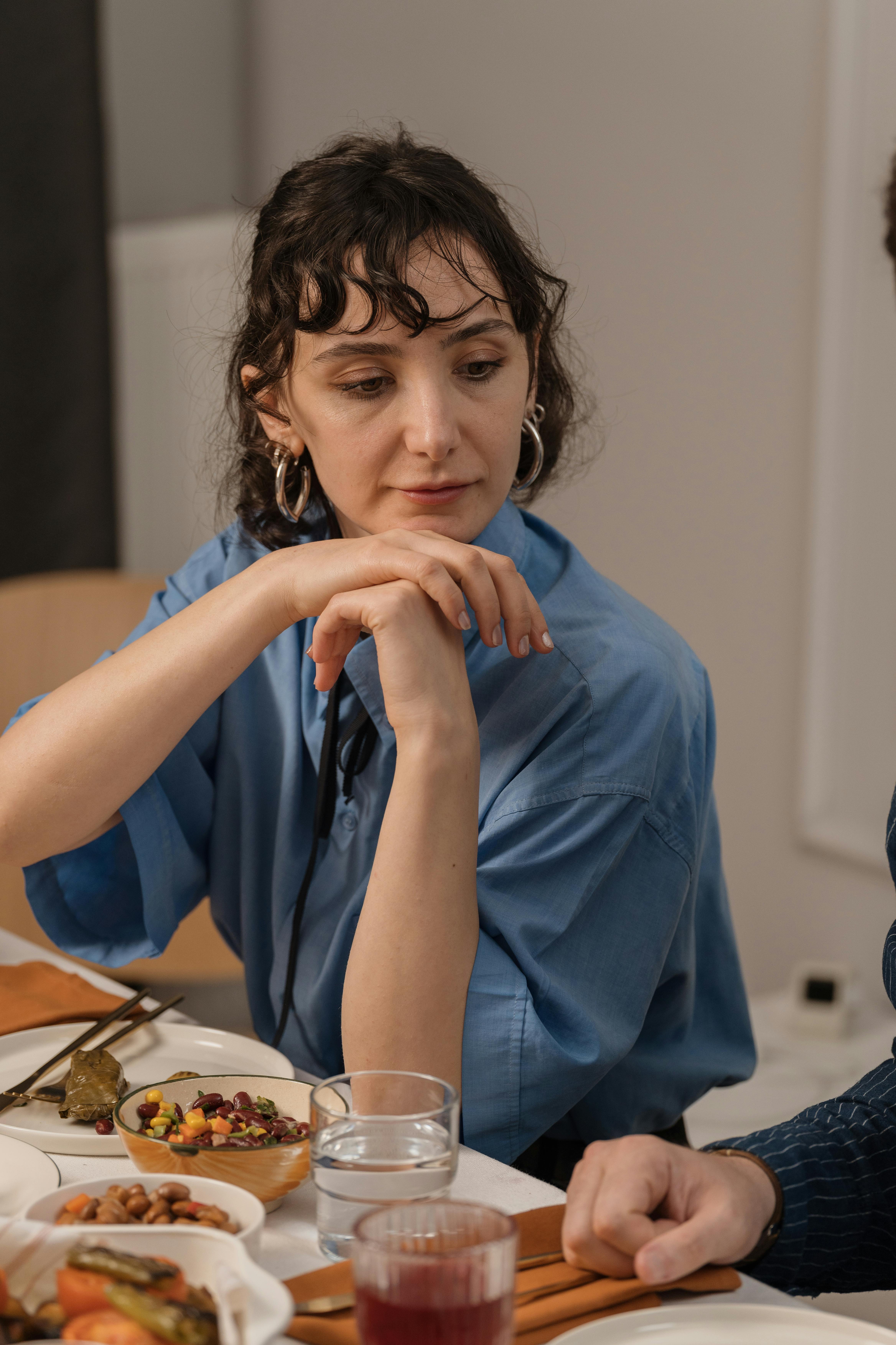 Une femme assise près de la table pendant le dîner | Source : Pexels
