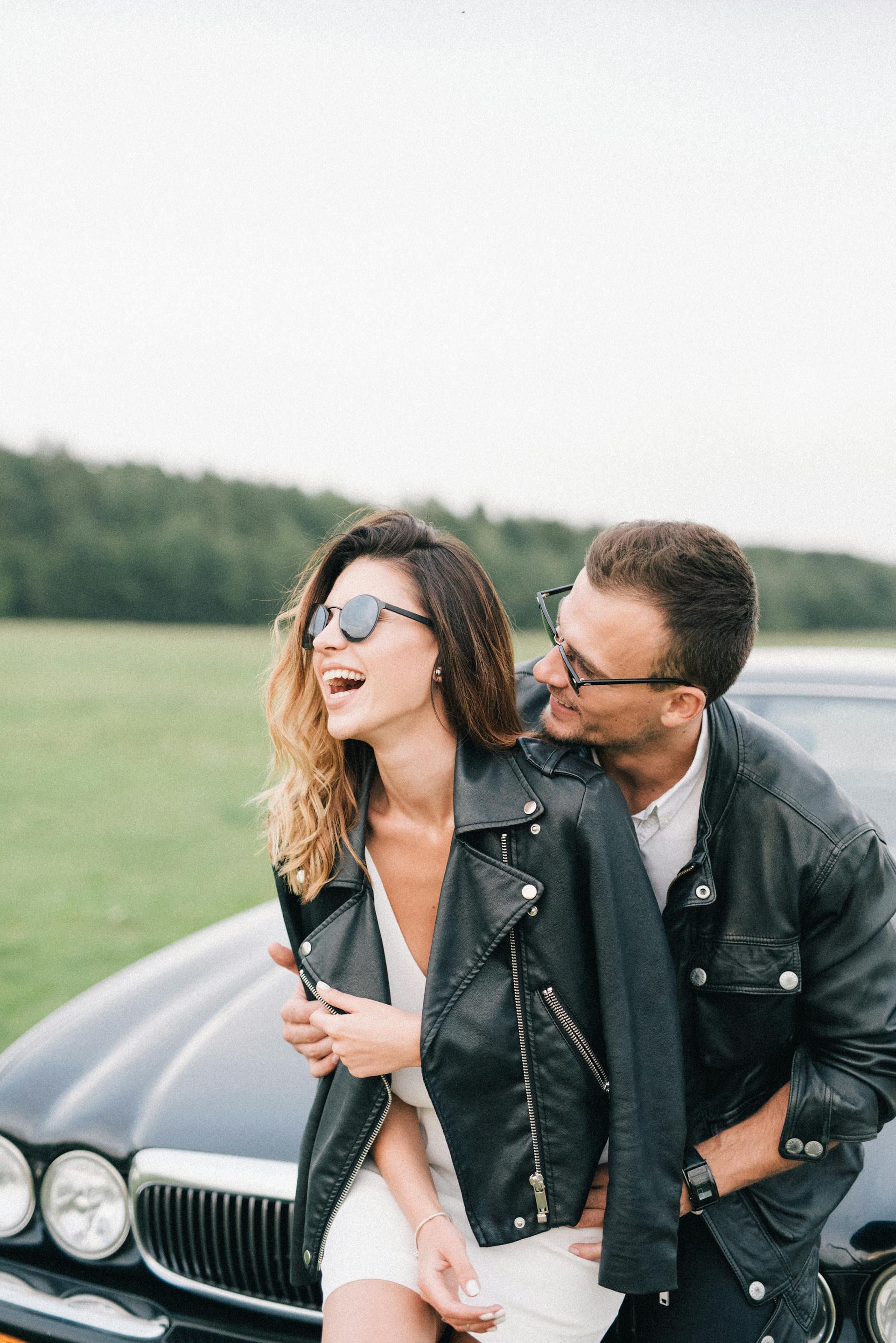 Un couple heureux debout devant une voiture | Source : Pexels
