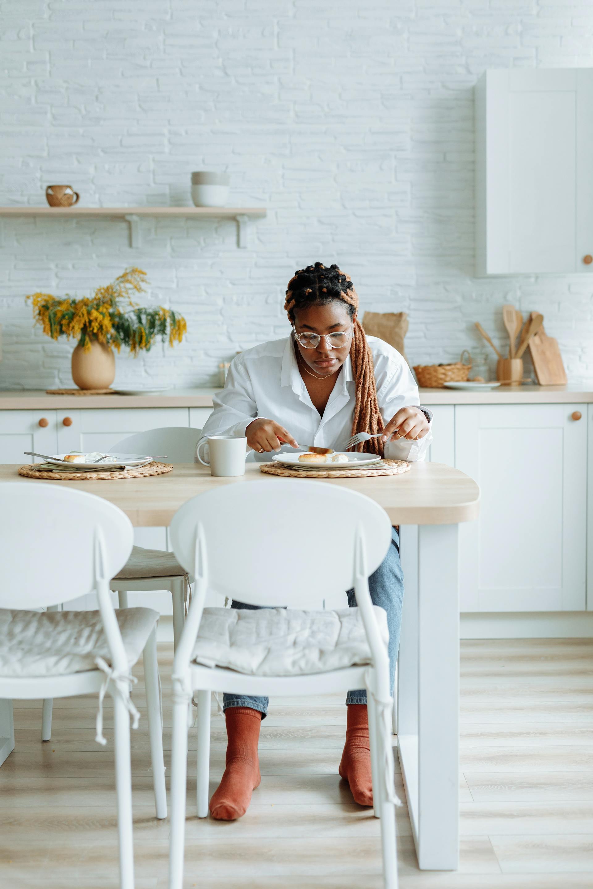 Une femme en train de manger dans la cuisine | Source : Pexels