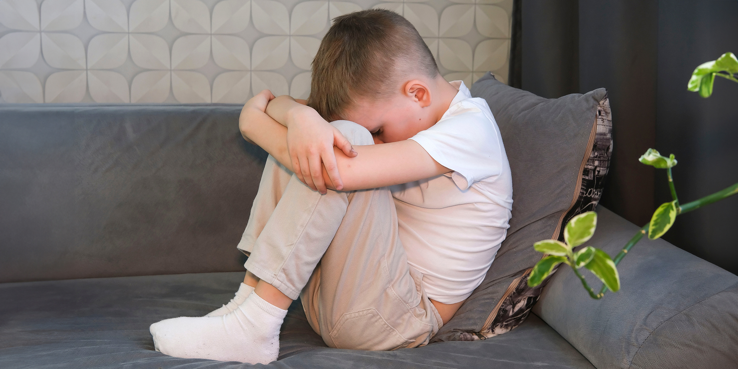 Un petit garçon bouleversé assis sur un canapé | Source : Shutterstock