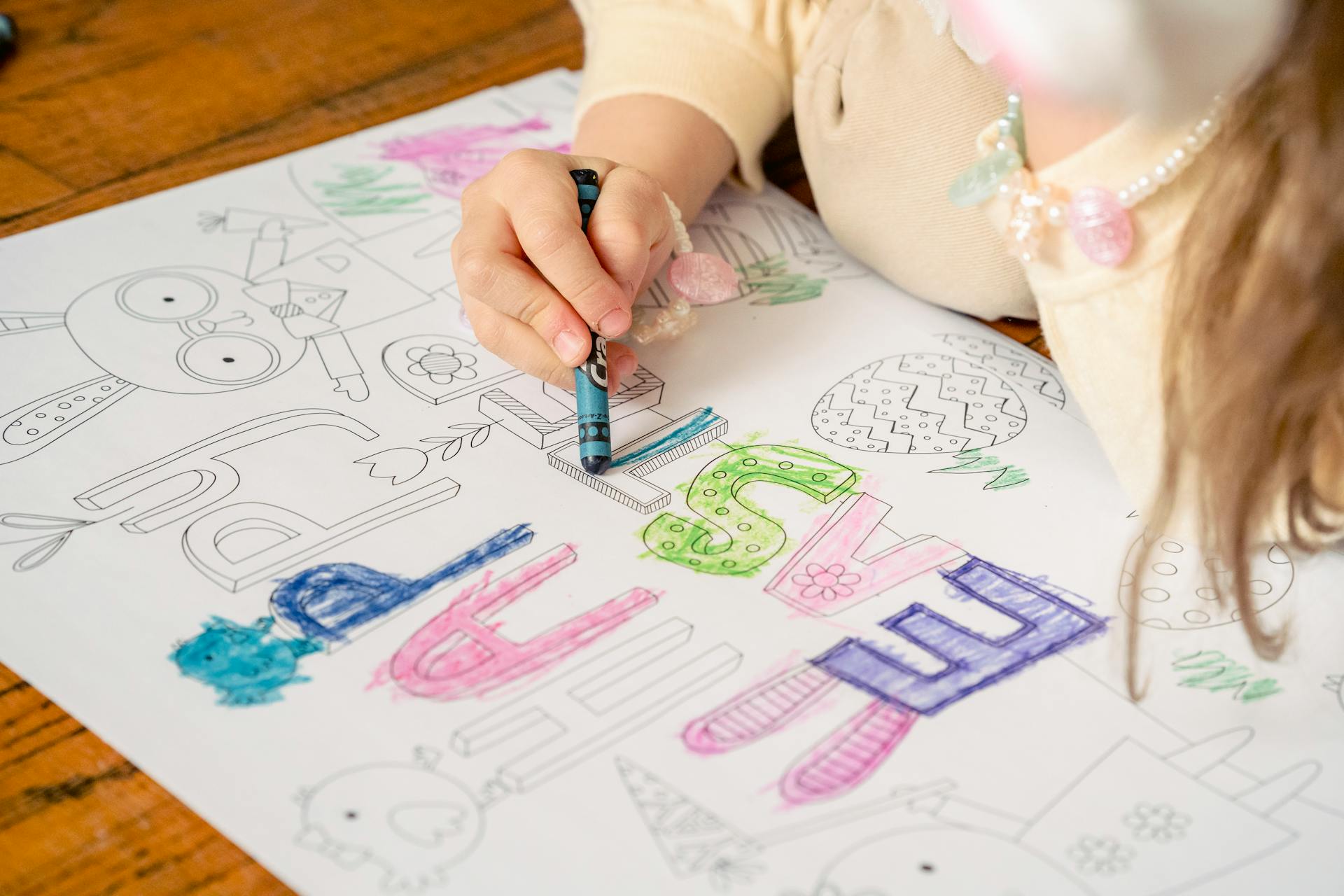 Gros plan sur une petite fille en train de colorier sur un papier | Source : Pexels