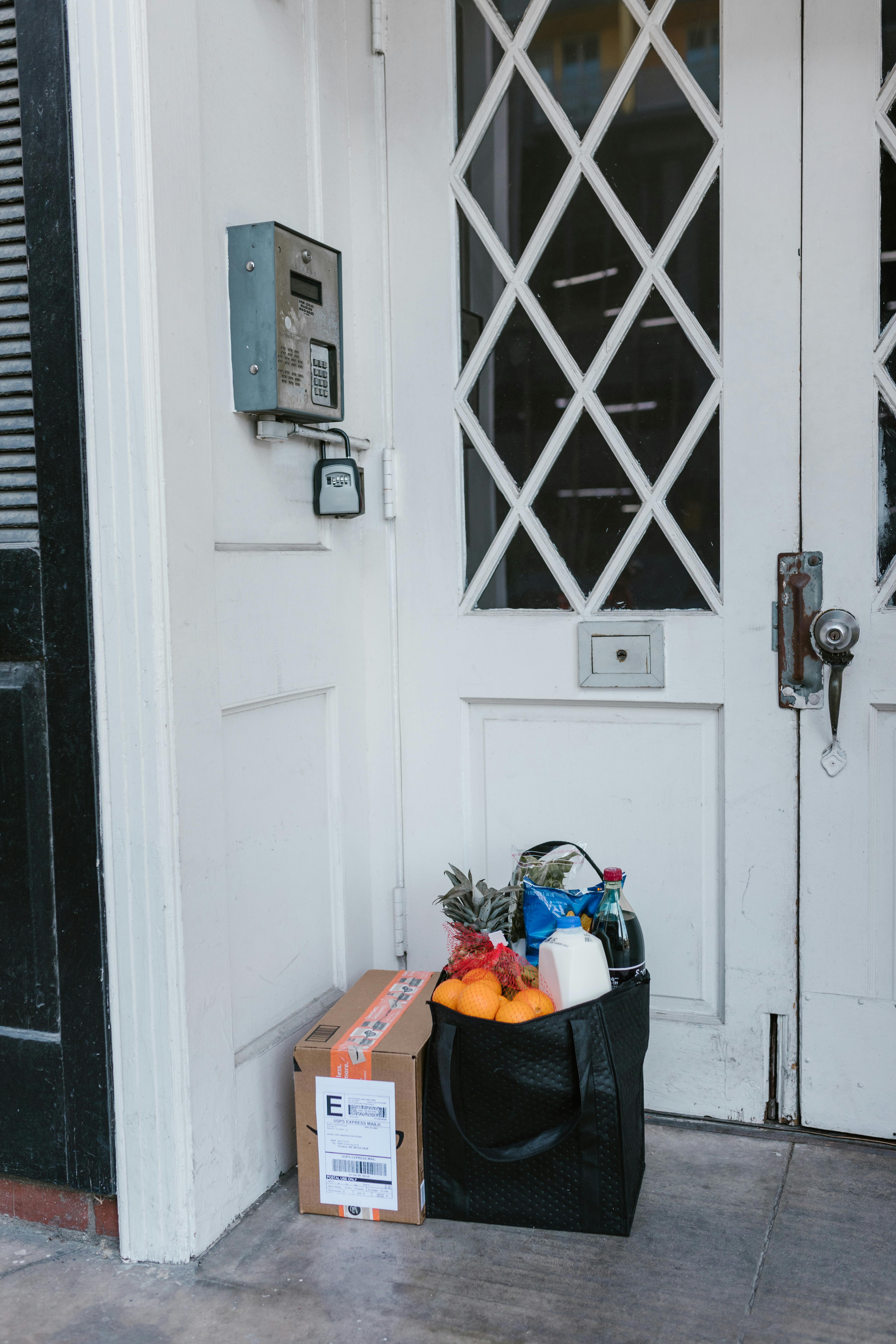 Sac d'épicerie et colis sur le pas de la porte | Source : Pexels